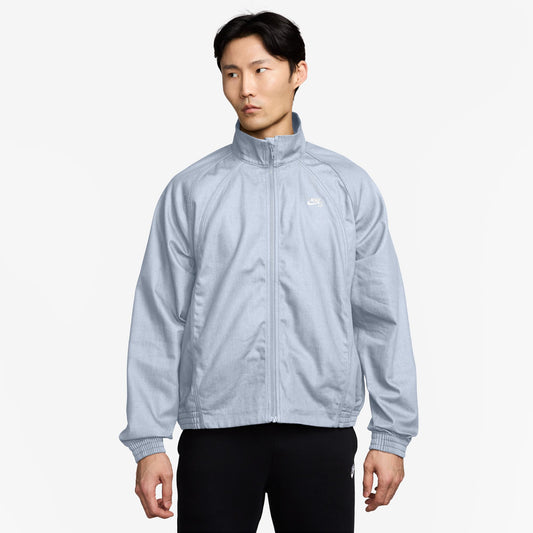Person wearing a light blue jacket on a white background
