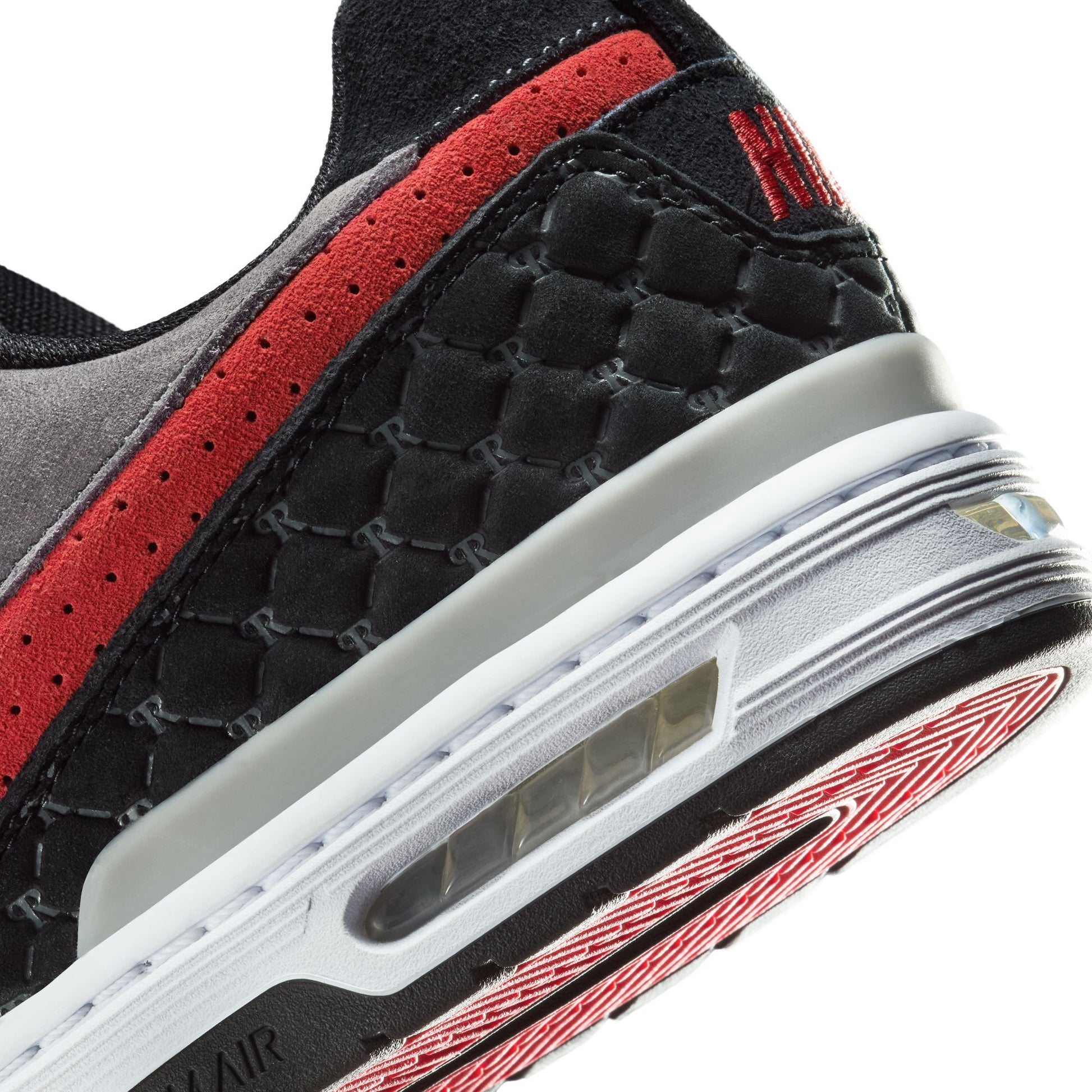 Close-up of a black and red sneaker with a white sole