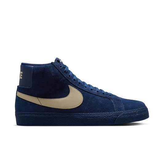 Blue high-top Nike sb blazer sneaker with beige swoosh logo on a white background