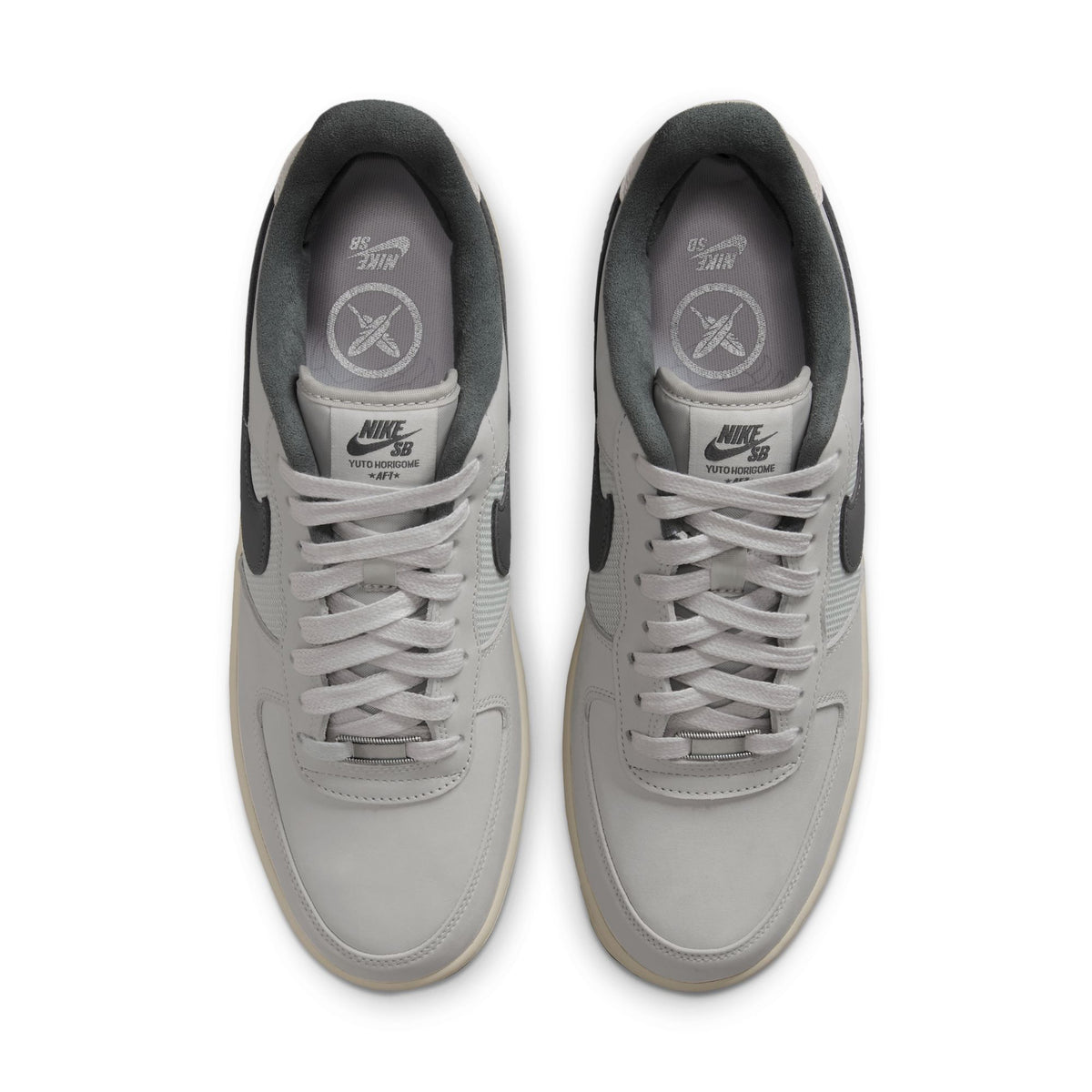 A pair of Nike Air Force 1 Low sneakers in light gray and dark gray, shown from a top-down view on a white background.