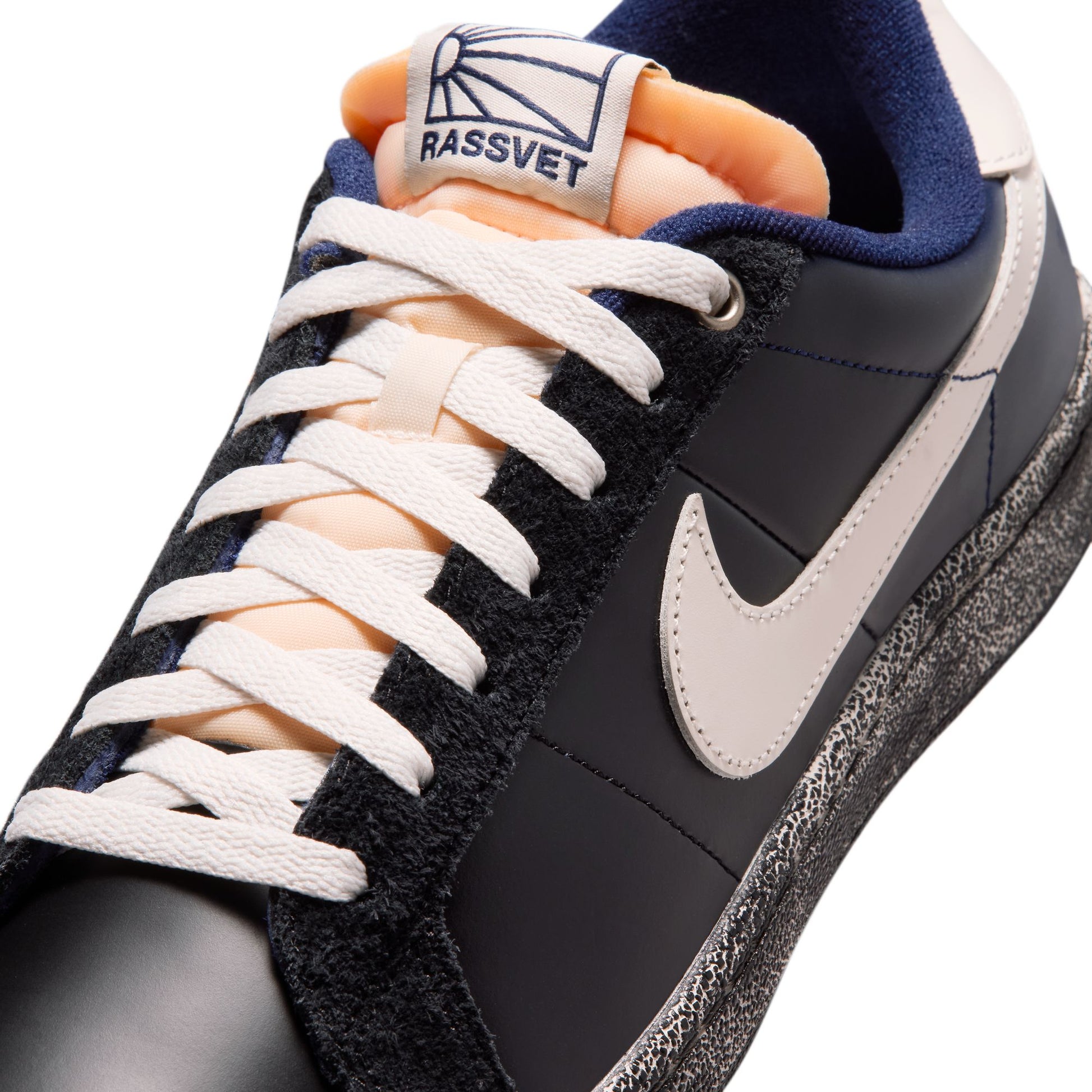close up view of Black and gray sneaker with white laces and a visible brand logo on a white background
