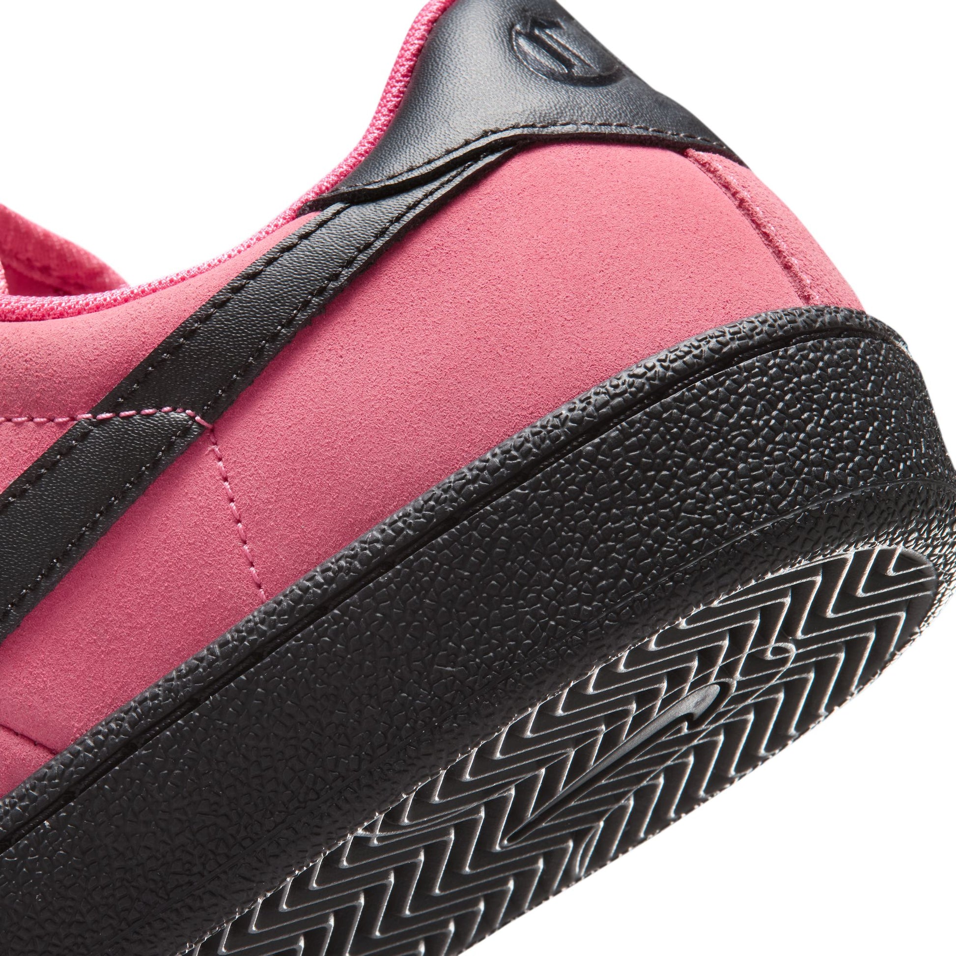 Close-up of a pink and black sneaker with tread pattern
