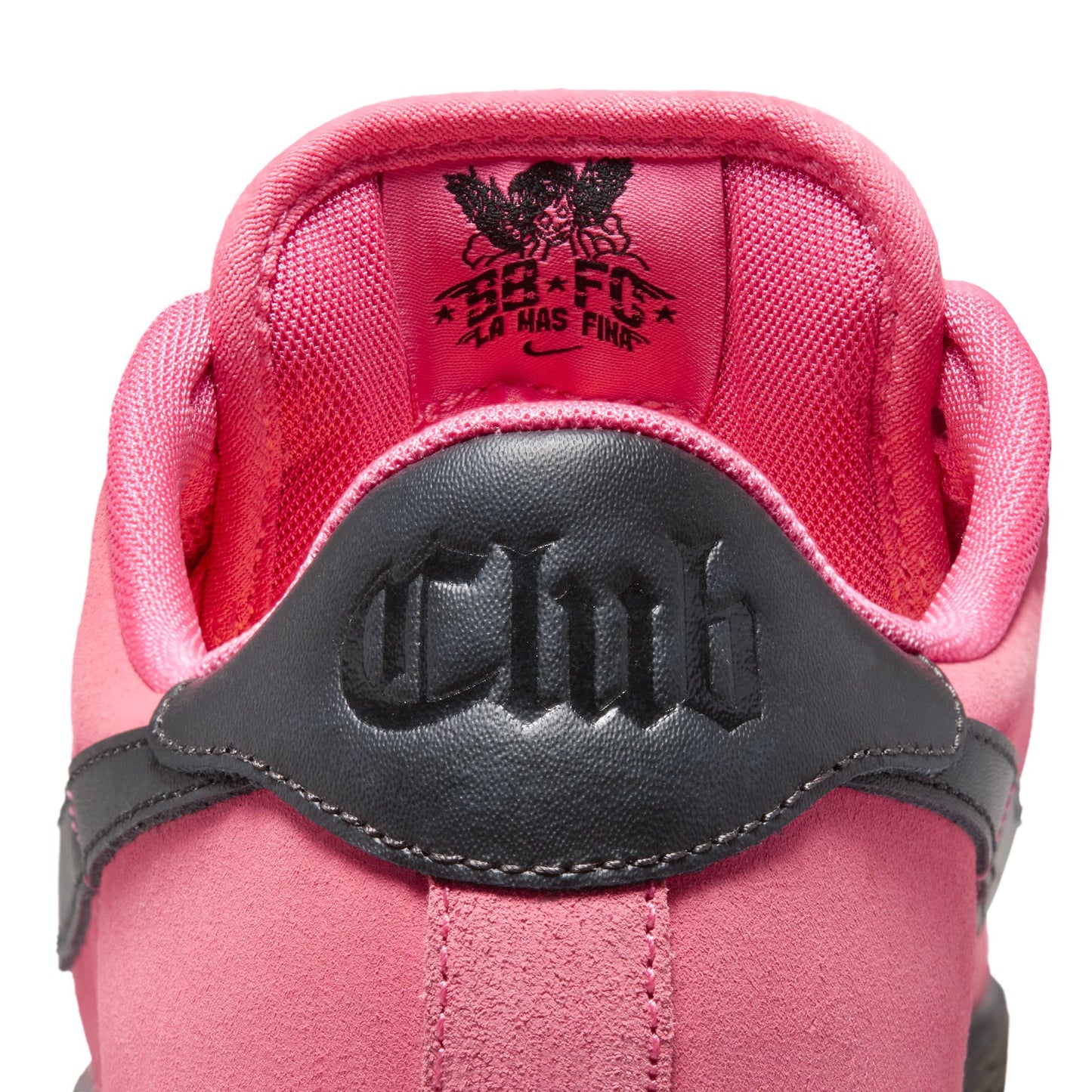Close-up of on heel tab of pink sneaker with a visible "CLUB" logo on heel tab, on a white background