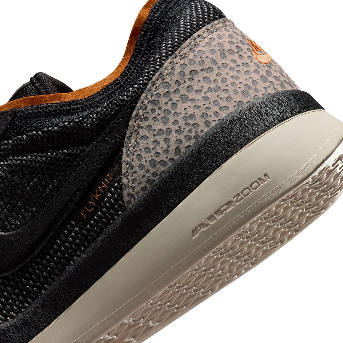 Close-up of a black and brown sneaker with 'Air Zoom' branding on a white background