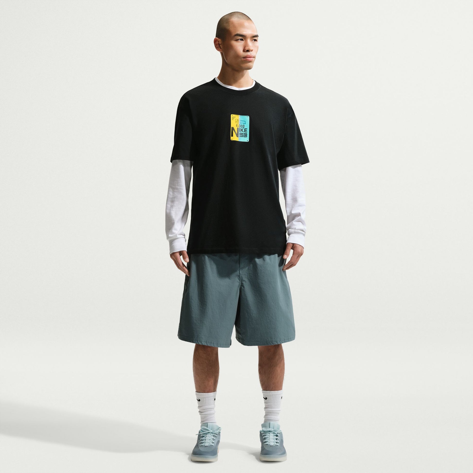 Man wearing a black t-shirt with a colorful graphic, on a white background.