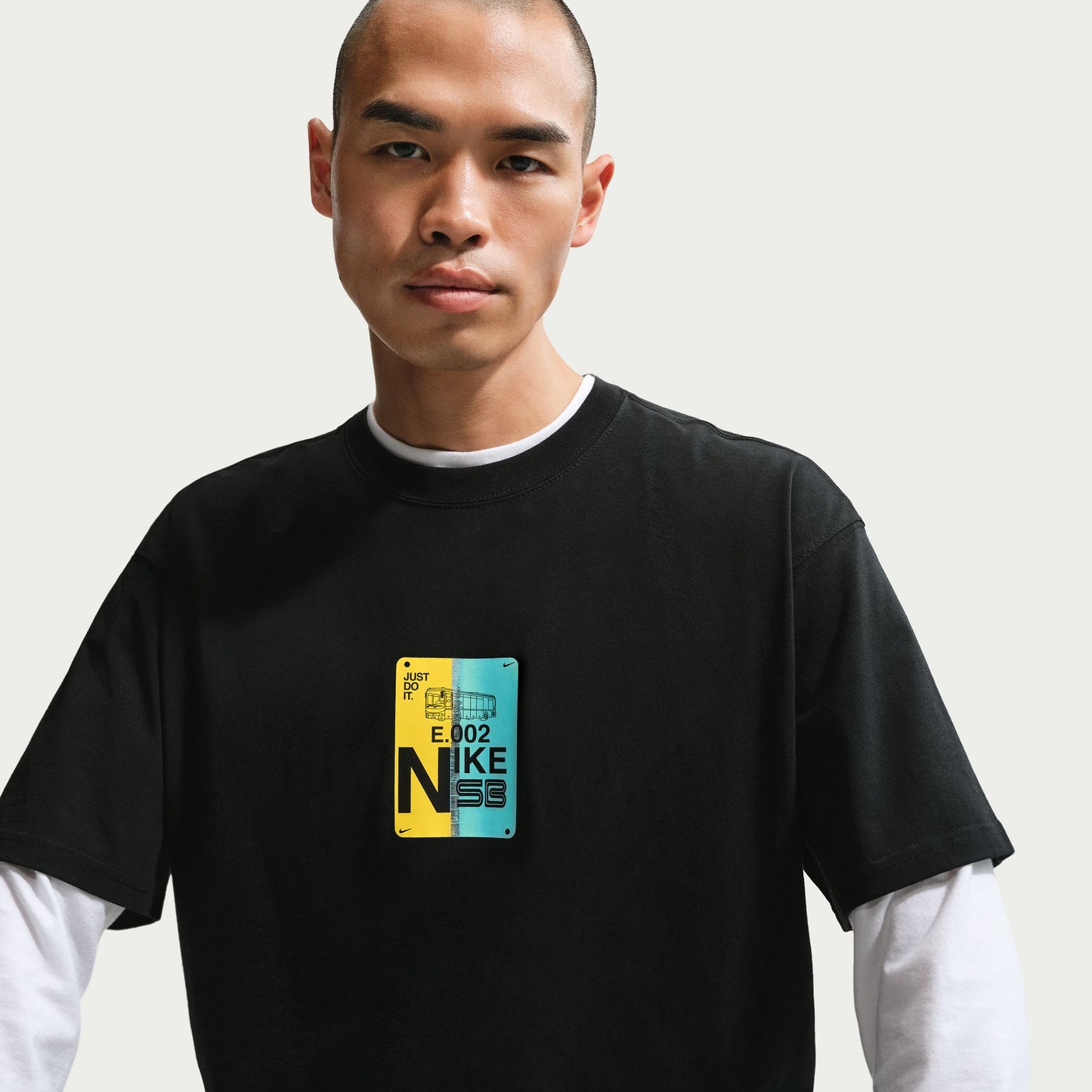 Person wearing a black t-shirt with a colorful logo on a plain background