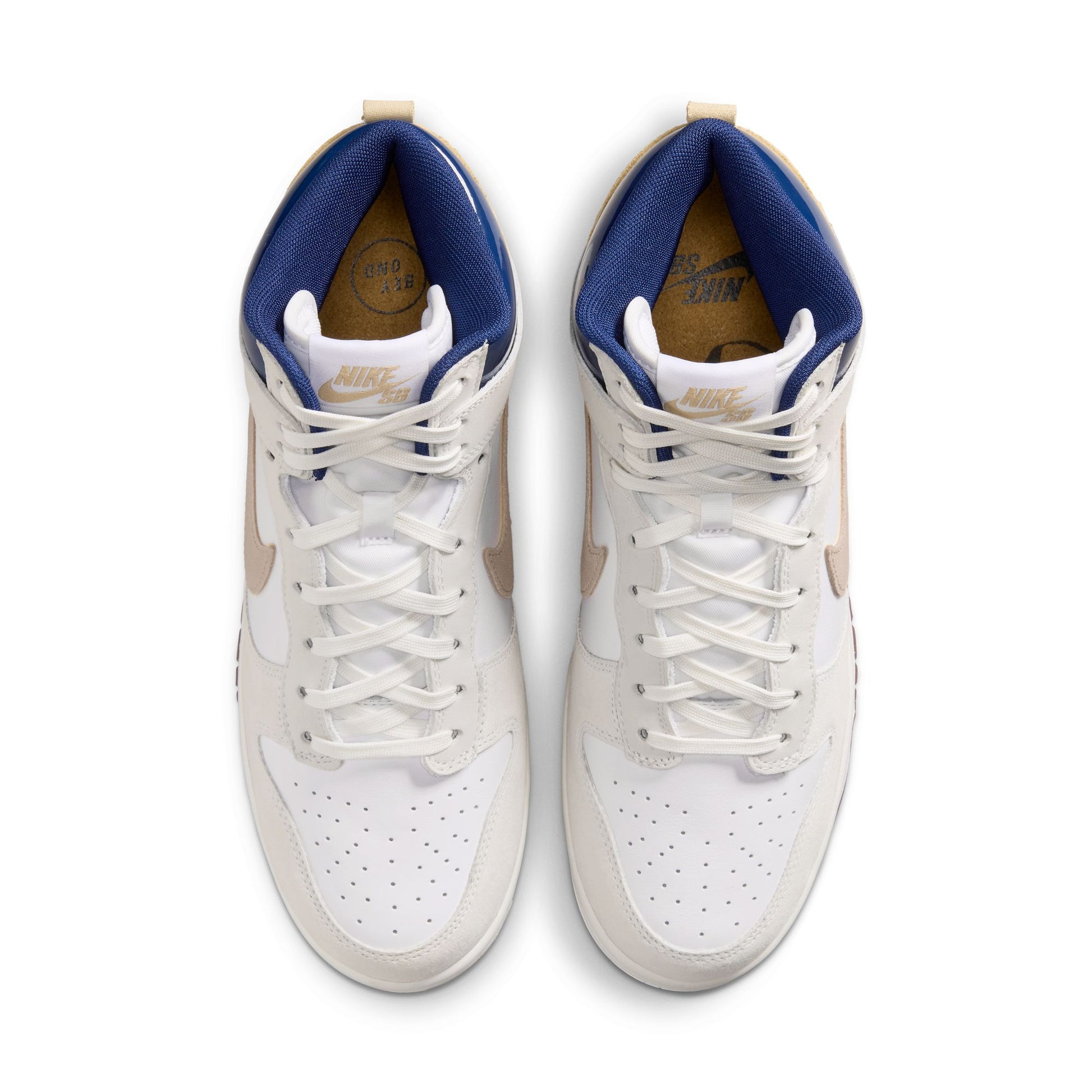 A pair of Nike Dunk SB sneakers shown from a top-down view. The shoes are primarily white leather with a white rubber toe cap, featuring a blue collar lining, beige Swooshes, and beige heel tabs.