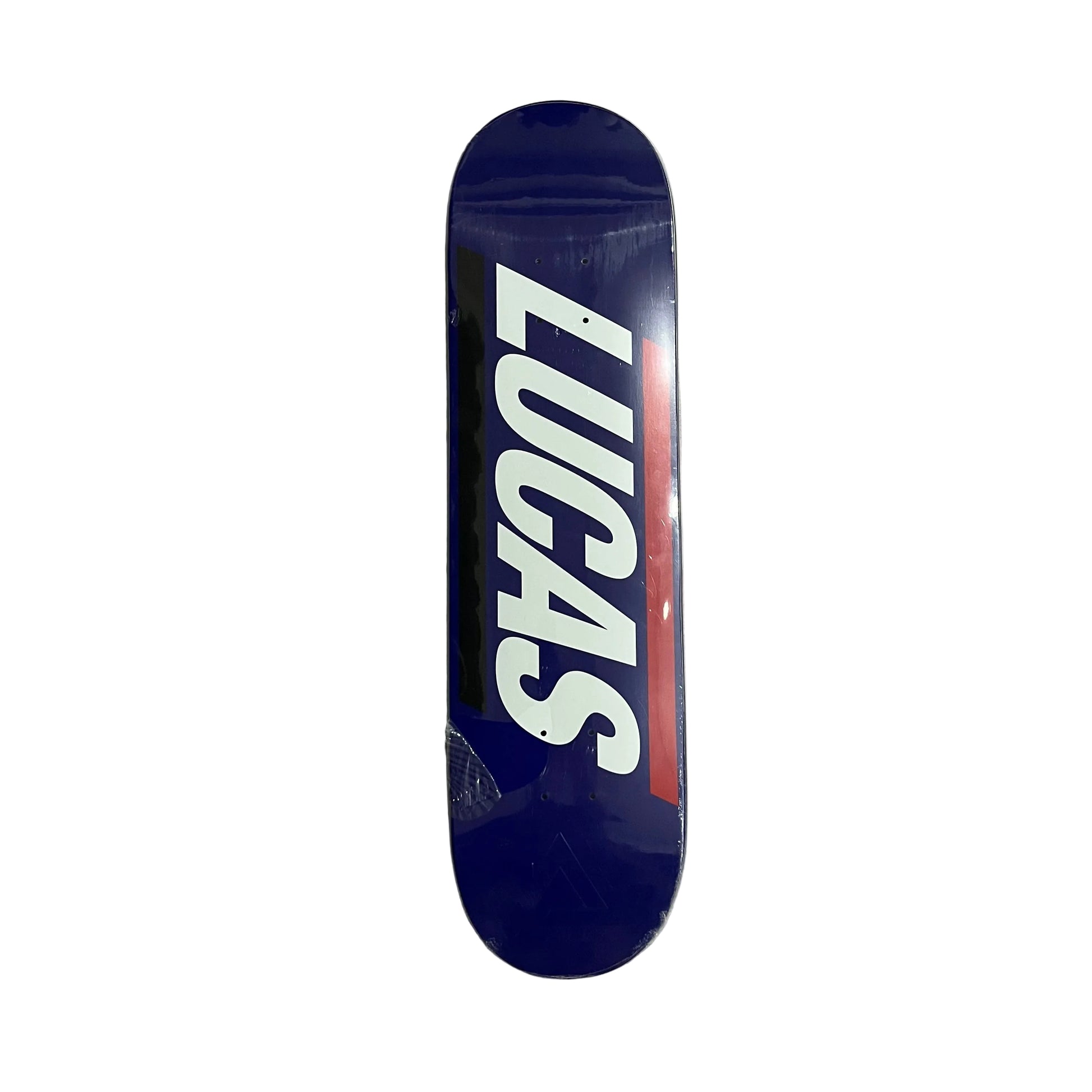 A skateboard deck with a dark blue background, featuring the name 'LUCAS' in large white letters with a red accent stripe, photographed from above on a white surface.