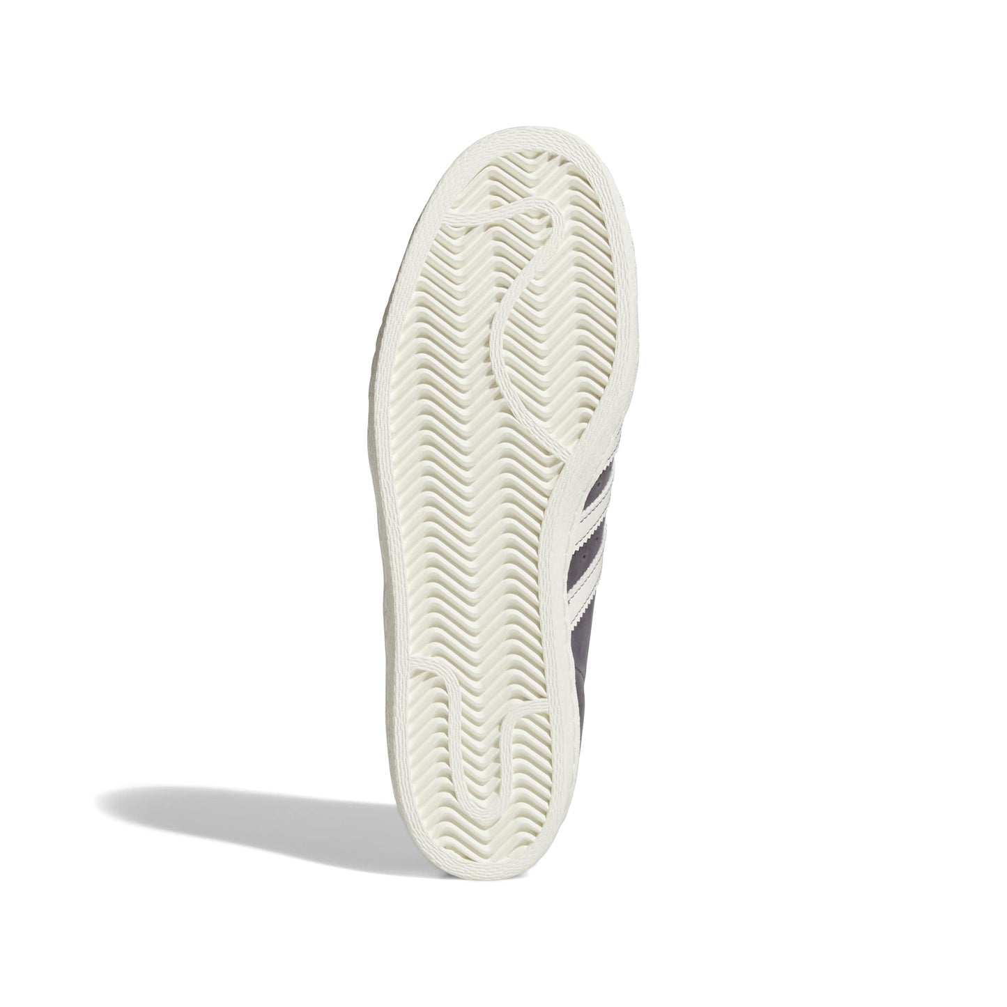 Close-up of a white sneaker sole with Adidas logo on a white background