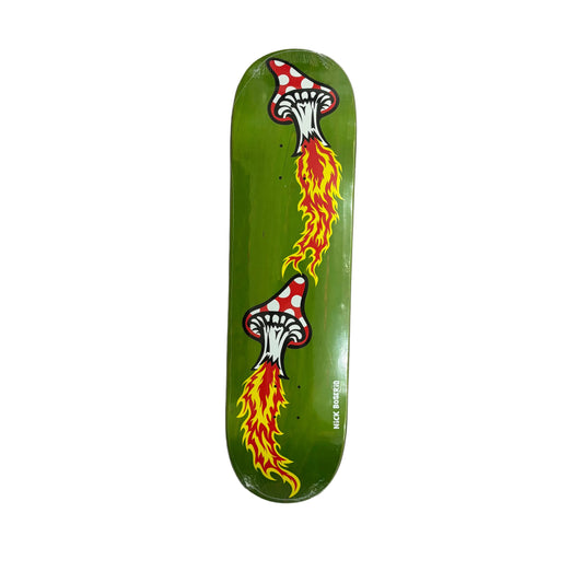 A green skateboard deck featuring a graphic design of two white mushrooms with red spots breathing out orange and yellow flames, photographed from above on a white surface.