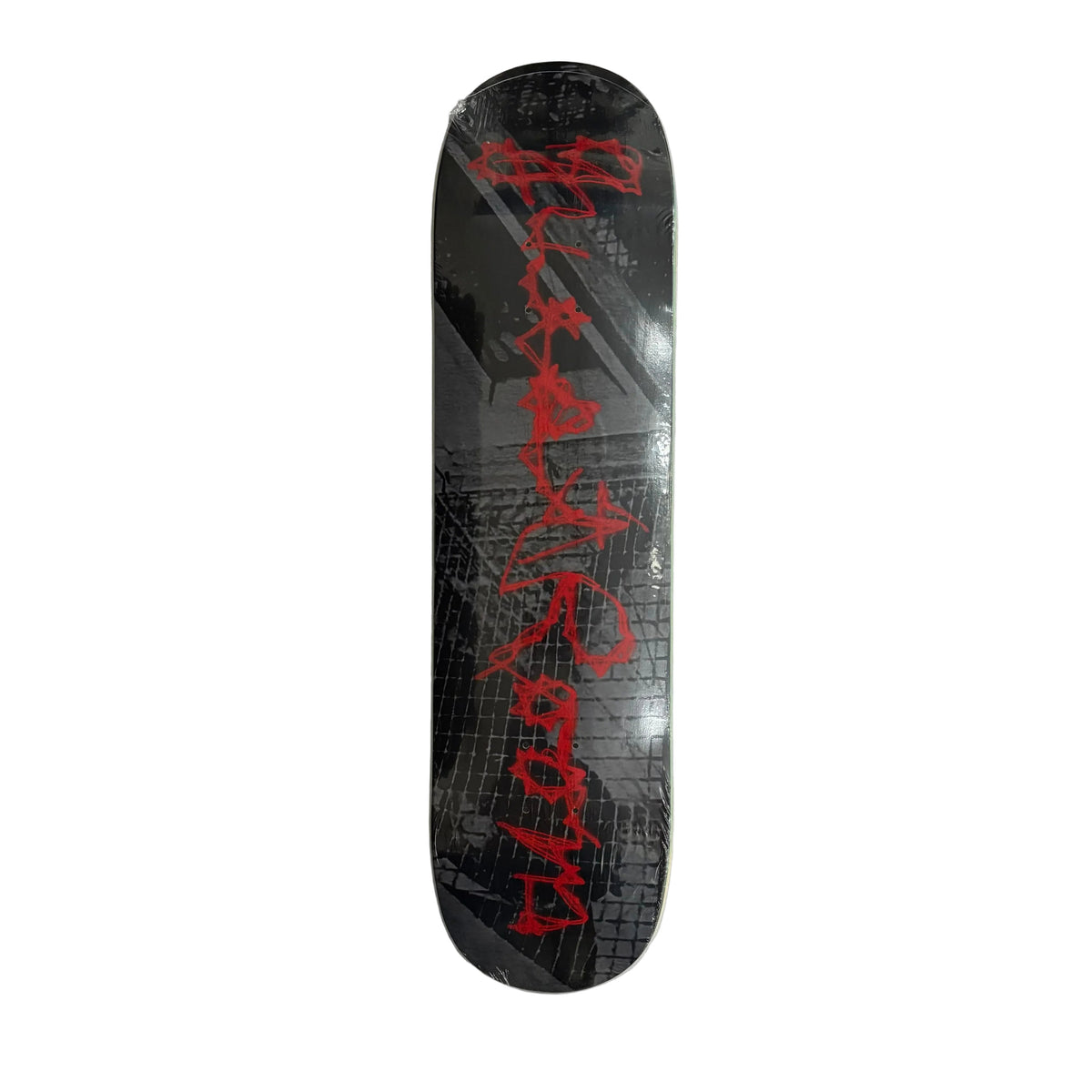 A skateboard deck, featuring a black and gray brick-patterned graphic with bold red graffiti-style lettering, displayed on a white surface.