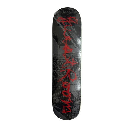 A skateboard deck, featuring a black and gray brick-patterned graphic with bold red graffiti-style lettering, displayed on a white surface.