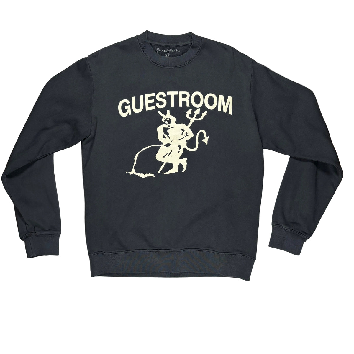 A black crewneck sweatshirt with a cream graphic of a devil and the word 'GUESTROOM' printed on the front, laid on a white surface.