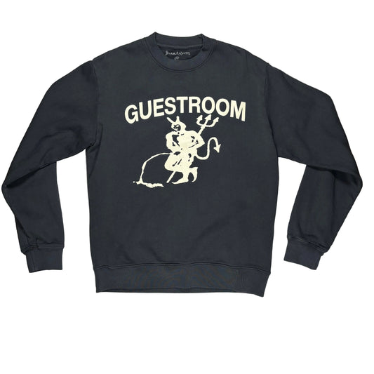 A black crewneck sweatshirt with a cream graphic of a devil and the word 'GUESTROOM' printed on the front, laid on a white surface.