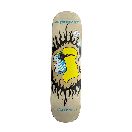 A vintage Krooked skateboard deck, pro model from Anderson, featuring a cream-colored base with a graphic of a yellow bird and blue-and-white striped feathers, surrounded by black flames, displayed on a white surface.