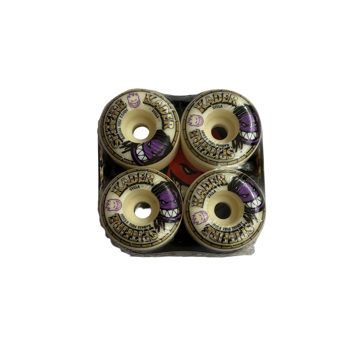 Four skateboard wheels arranged in a 2x2 grid inside a clear plastic tray, photographed from above on a white surface. The wheels have cream-colored urethane, black and gold graphics, and purple accents.