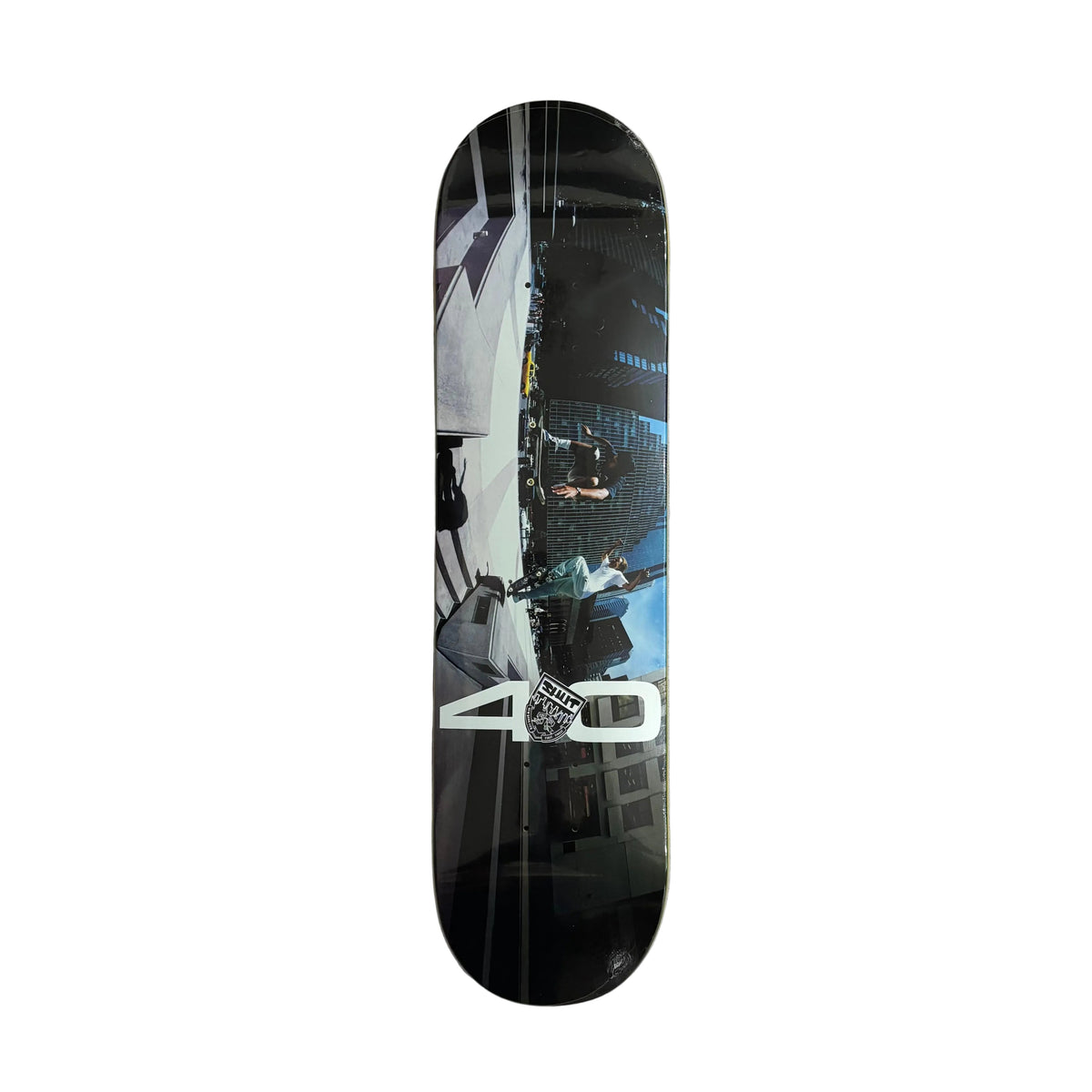 A skateboard deck with a glossy black background and a printed graphic of a street scene, featuring a large white '40' and a 'Skate' logo, displayed vertically on a white surface.