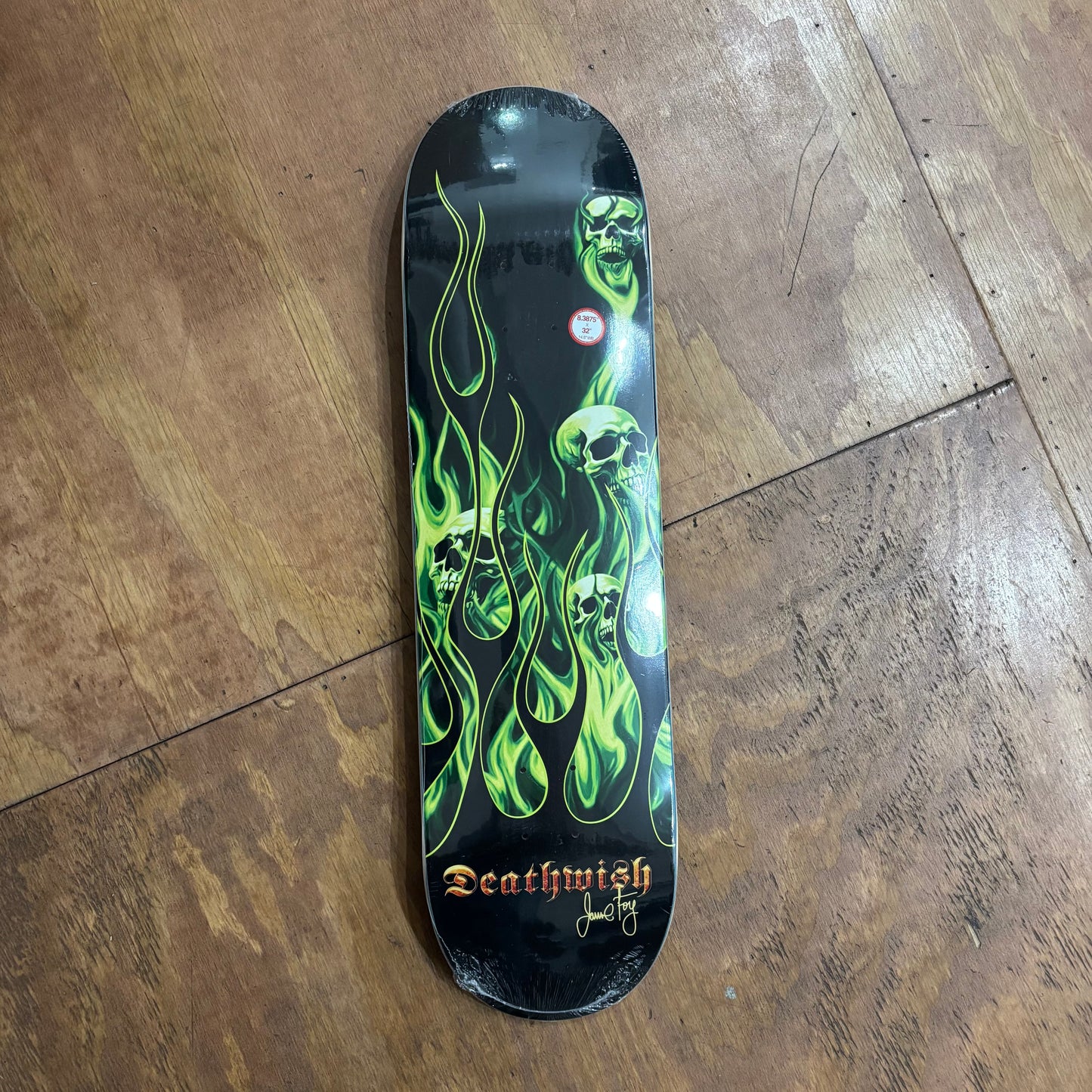 green skulls and flames on black skateboard deck