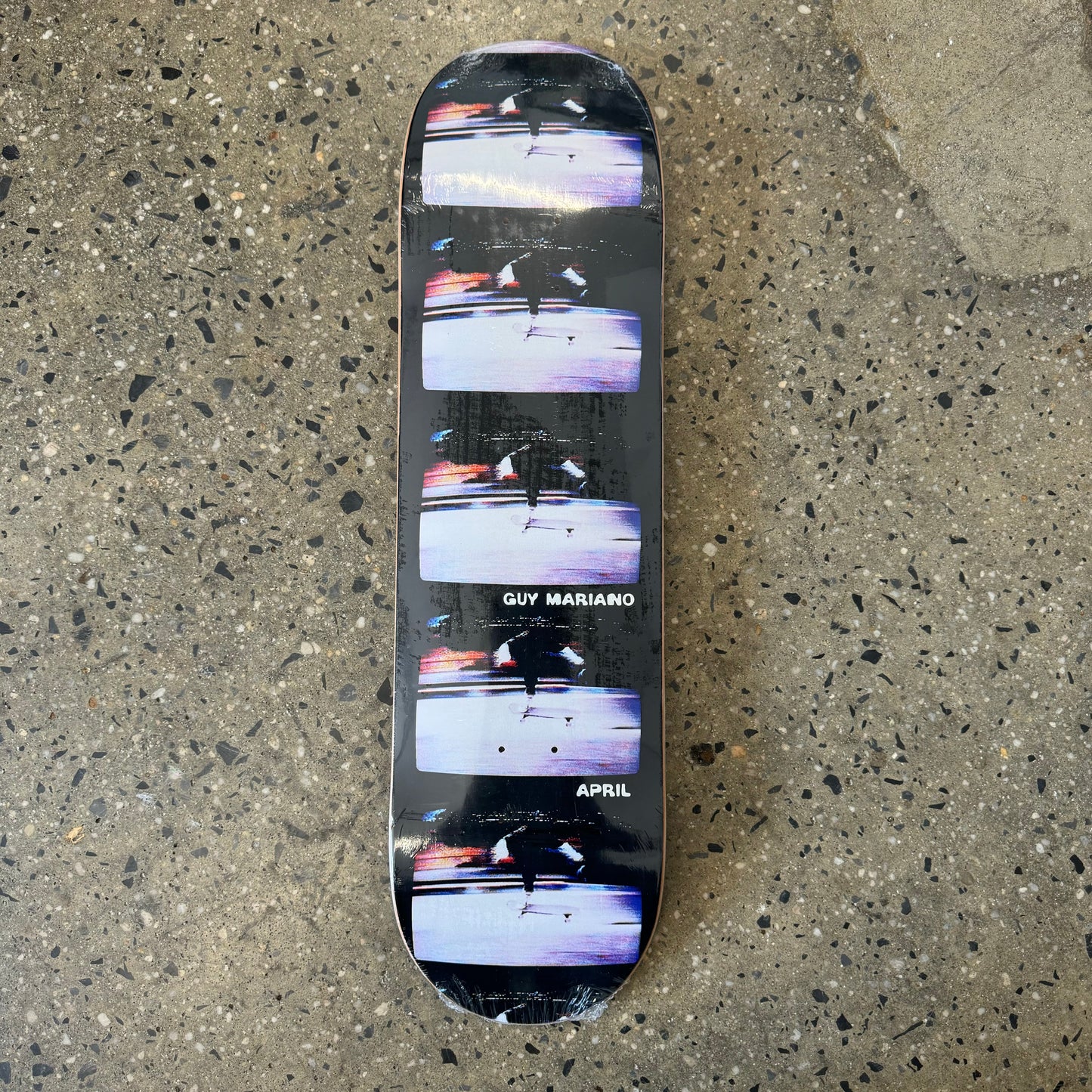 black skateboard deck with a photo of a young boy skateboarding