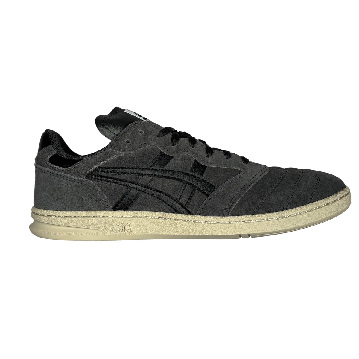 A single dark gray suede sneaker with black accents and a cream-colored sole, photographed from a side angle on a white surface.
