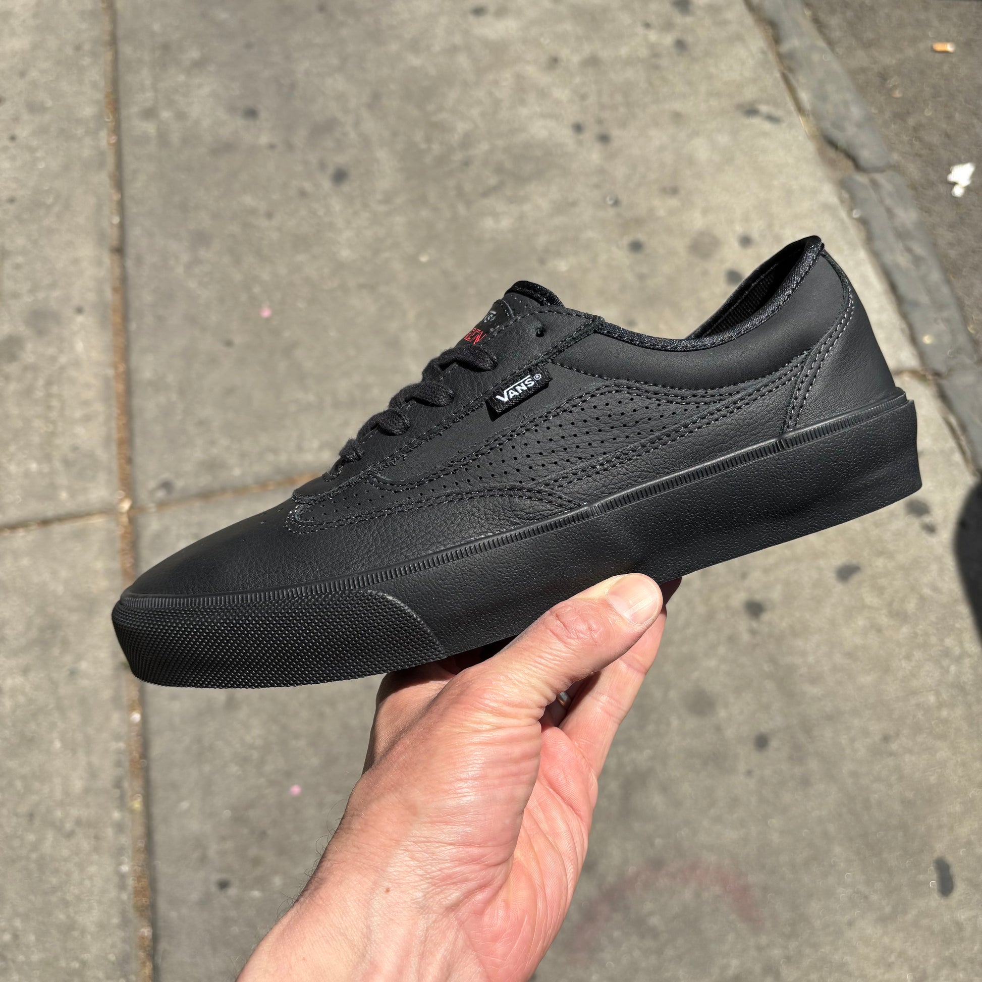 side view of black leather low top vans skateboard sneaker