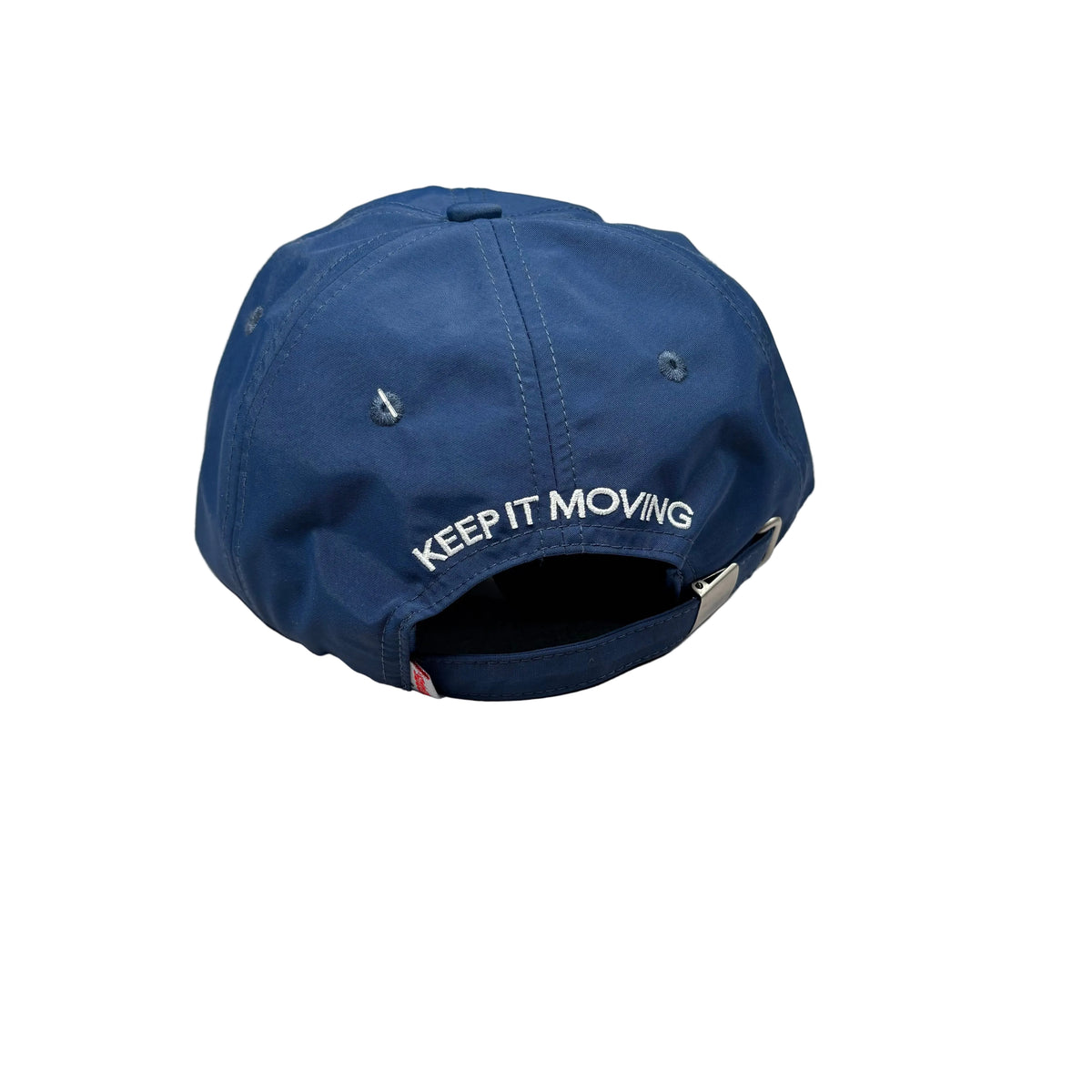 A navy blue baseball cap with 'KEEP IT MOVING' embroidered in white on the back, resting on a white surface.