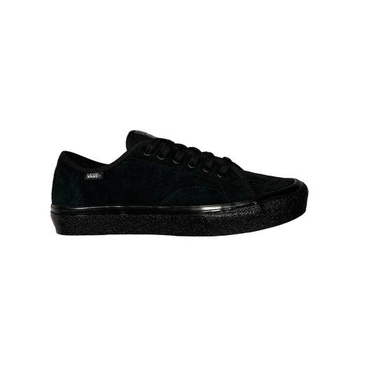A black low-top sneaker with a suede and leather mix upper, black laces, and a thick black platform sole, shown from the side against a white background.