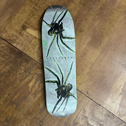 shaped skateboard deck with spider graphic on the bottom