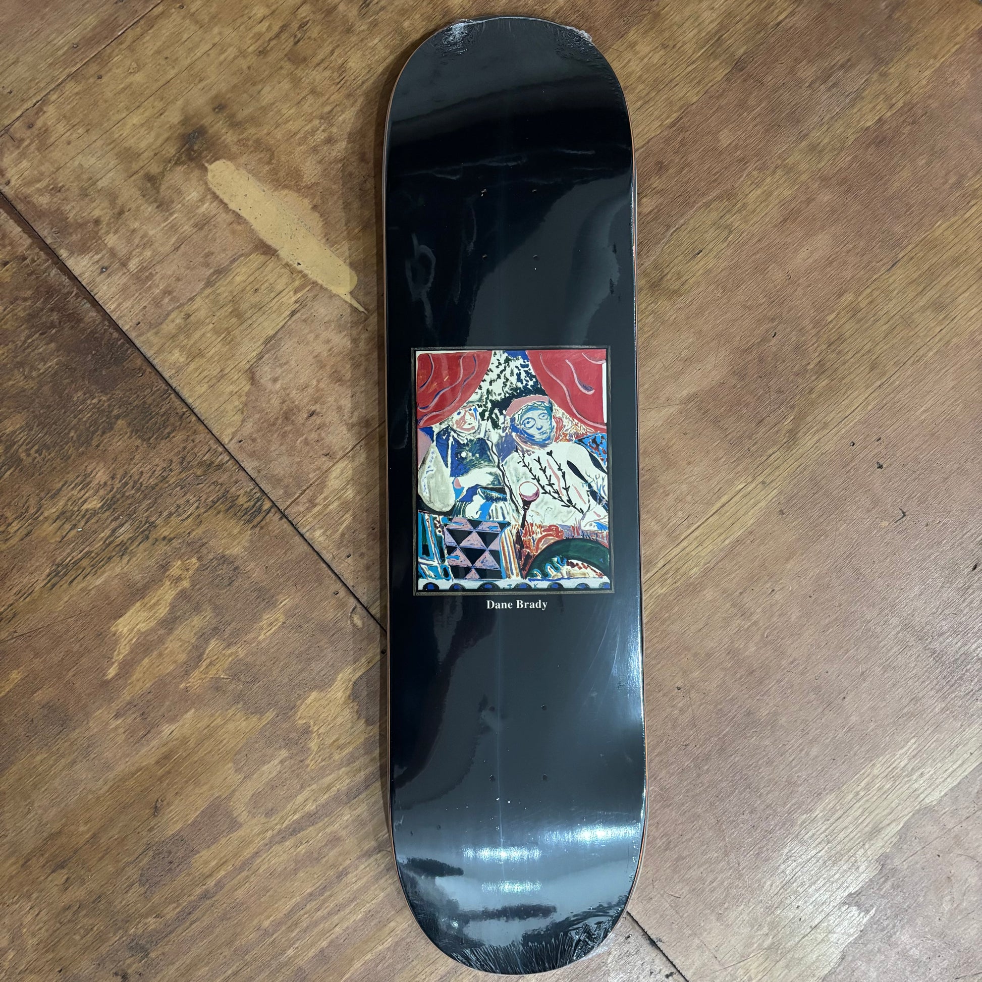brown background skate deck with watercolor impressionist style graphic on center of deck