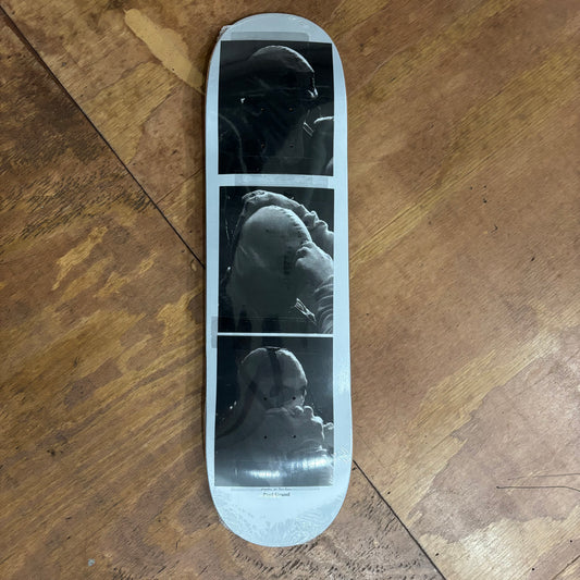 three polaroid photos vertically on bottom of skateboard deck