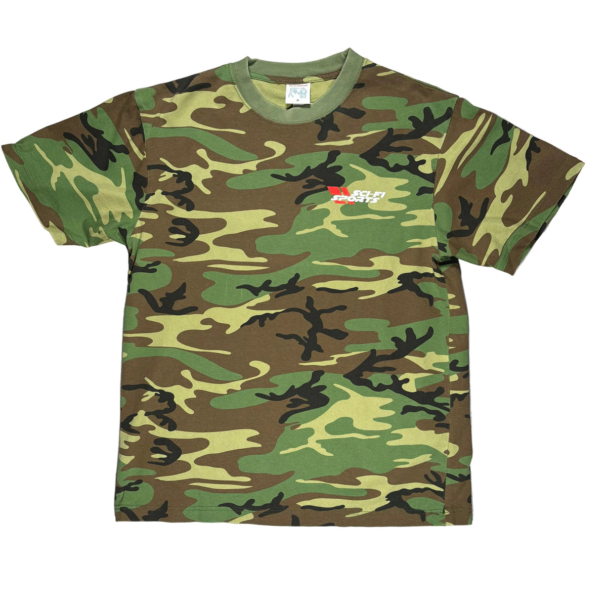 A short-sleeve crewneck t-shirt in a classic green, brown, and black camouflage pattern, laid flat on a white background. A small red and white SCI Fi SPORTS graphic is printed on the left chest.