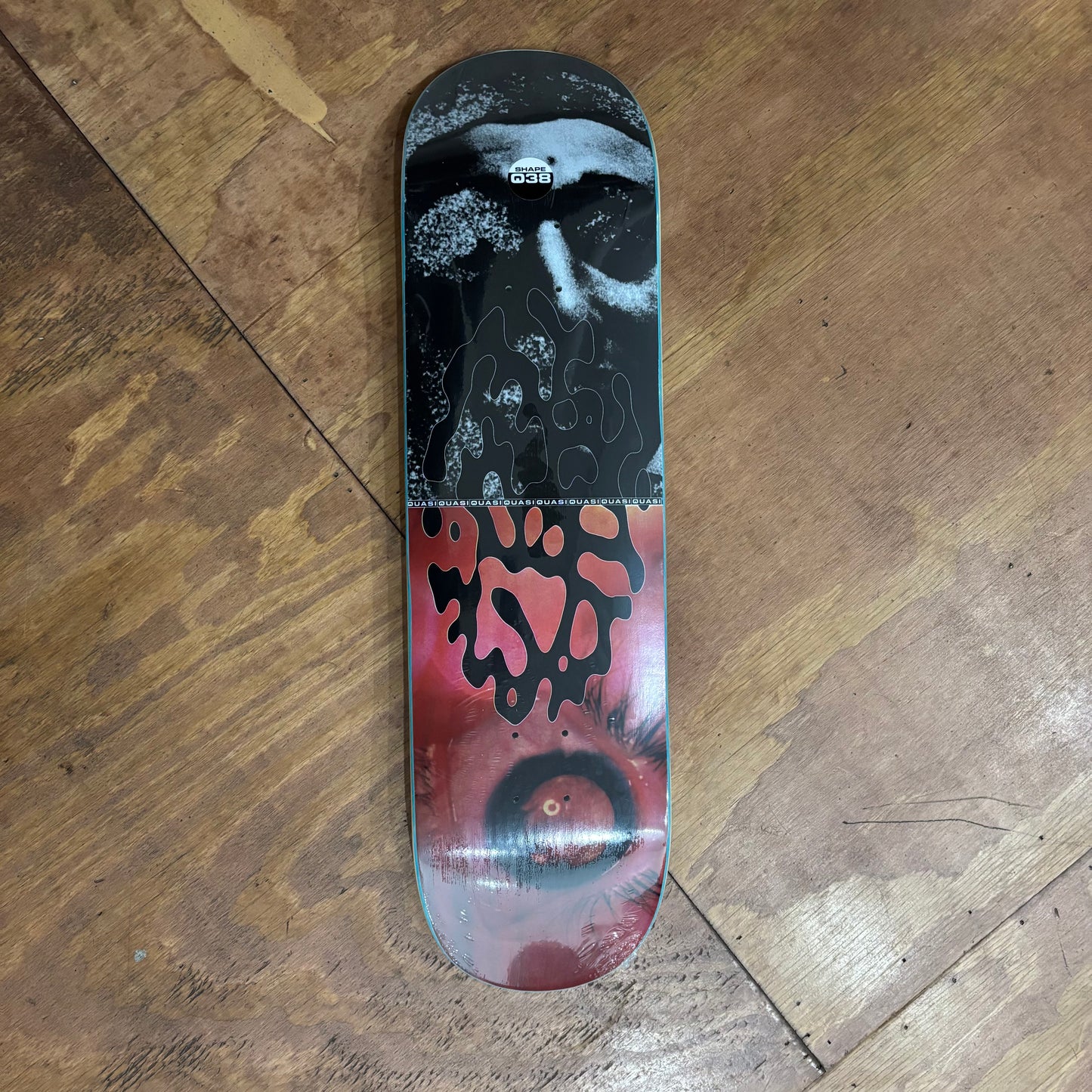 collage style skateboard deck with black upper half, and red lower half
