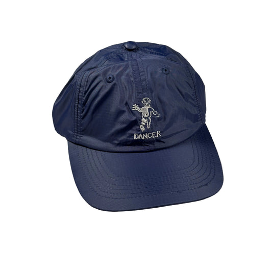 A navy blue baseball cap with a white embroidered dancer figure and the word 'DANCER' on the front, displayed on a white surface.