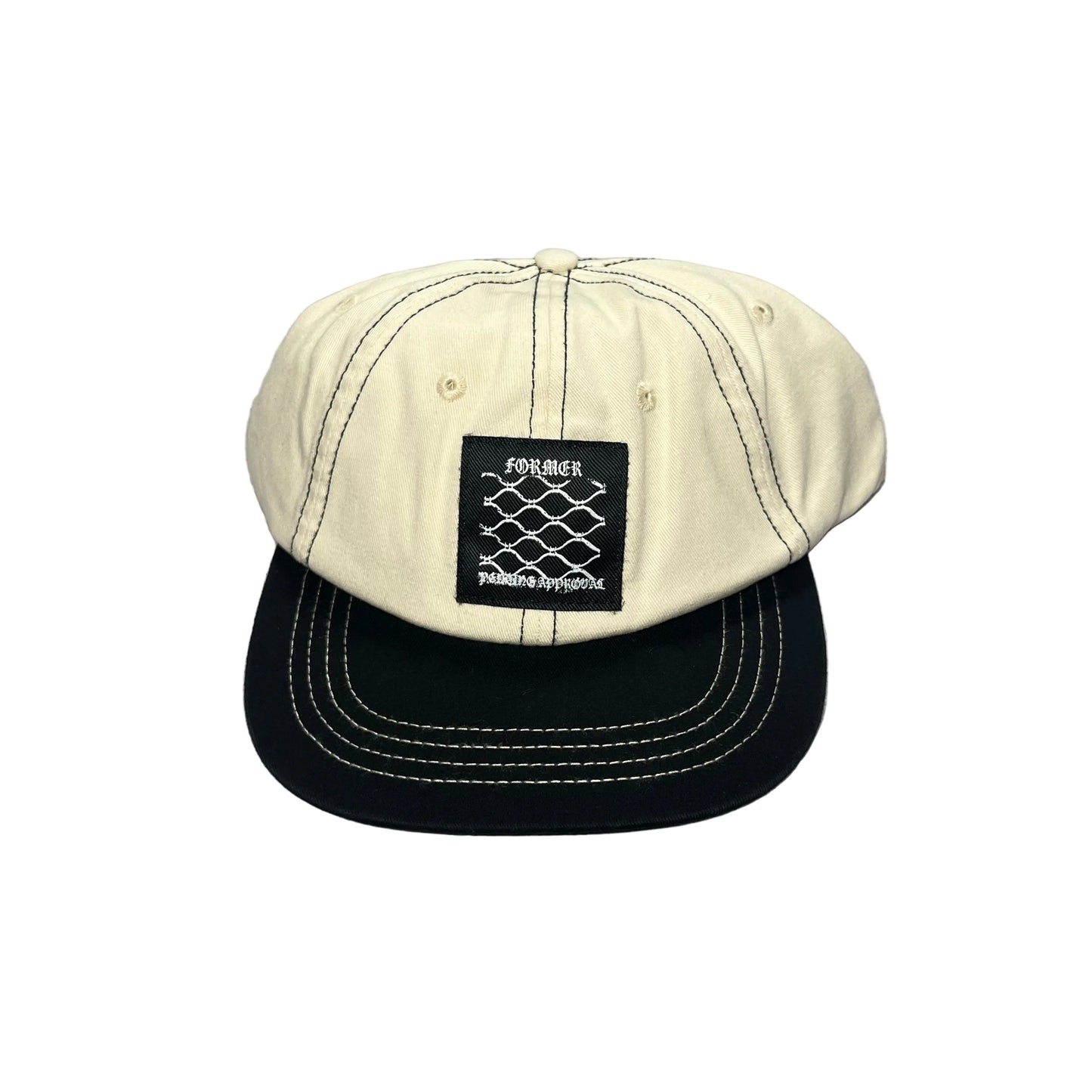 A two-tone baseball cap with an off-white/cream crown and a black flat brim, featuring white contrast stitching and a black front patch with the brand name FORMER