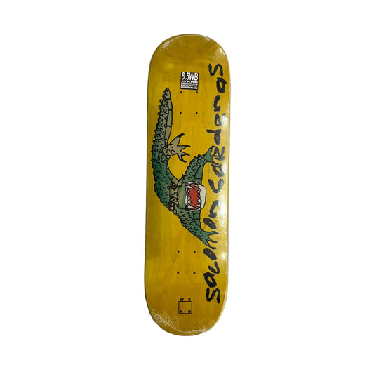 A yellow skateboard deck with a green dragon graphic and the text 'Solomon cardenas' printed on it, photographed flat on a white surface