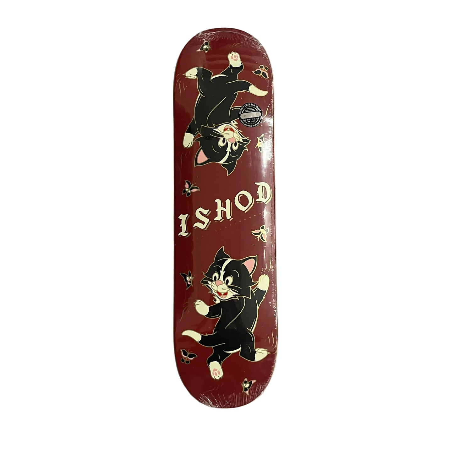 A red skateboard deck in shrink wrap, featuring cartoon black-and-white cats and the text 'ISHOD' on a gray white surface.