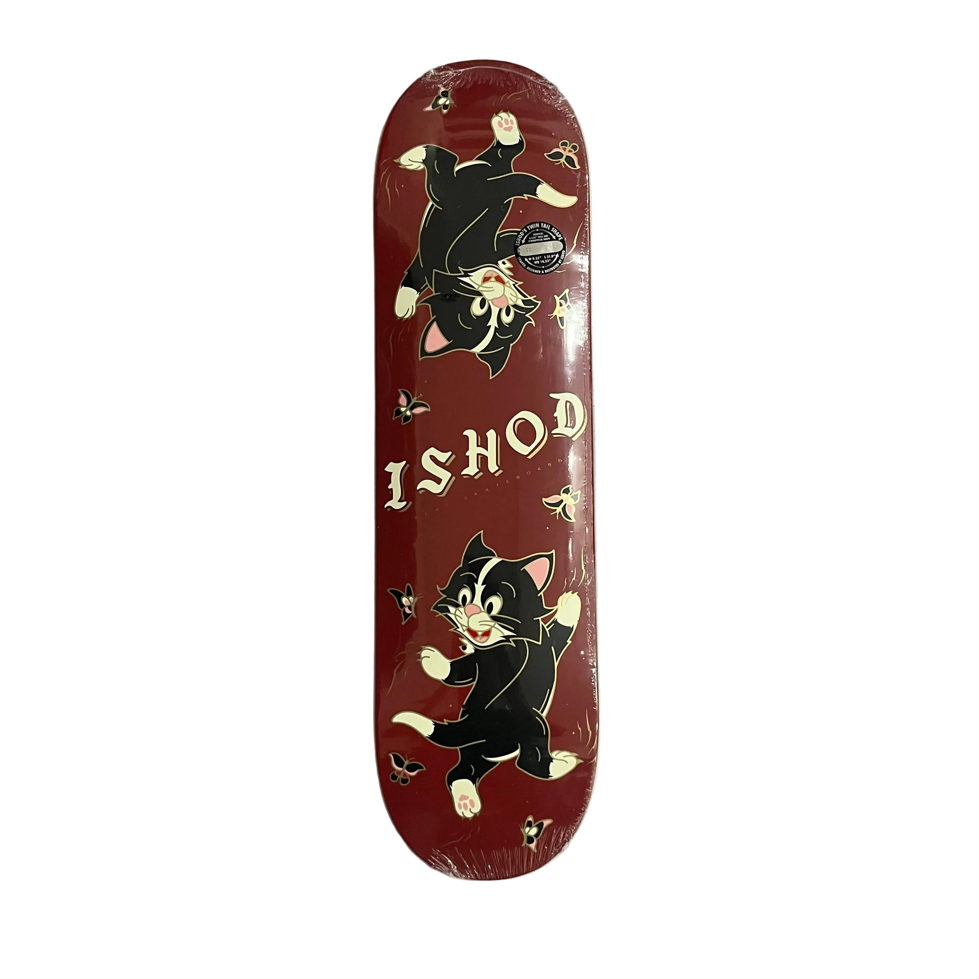 A red skateboard deck in shrink wrap, featuring cartoon black-and-white cats and the text 'ISHOD' on a gray white surface.