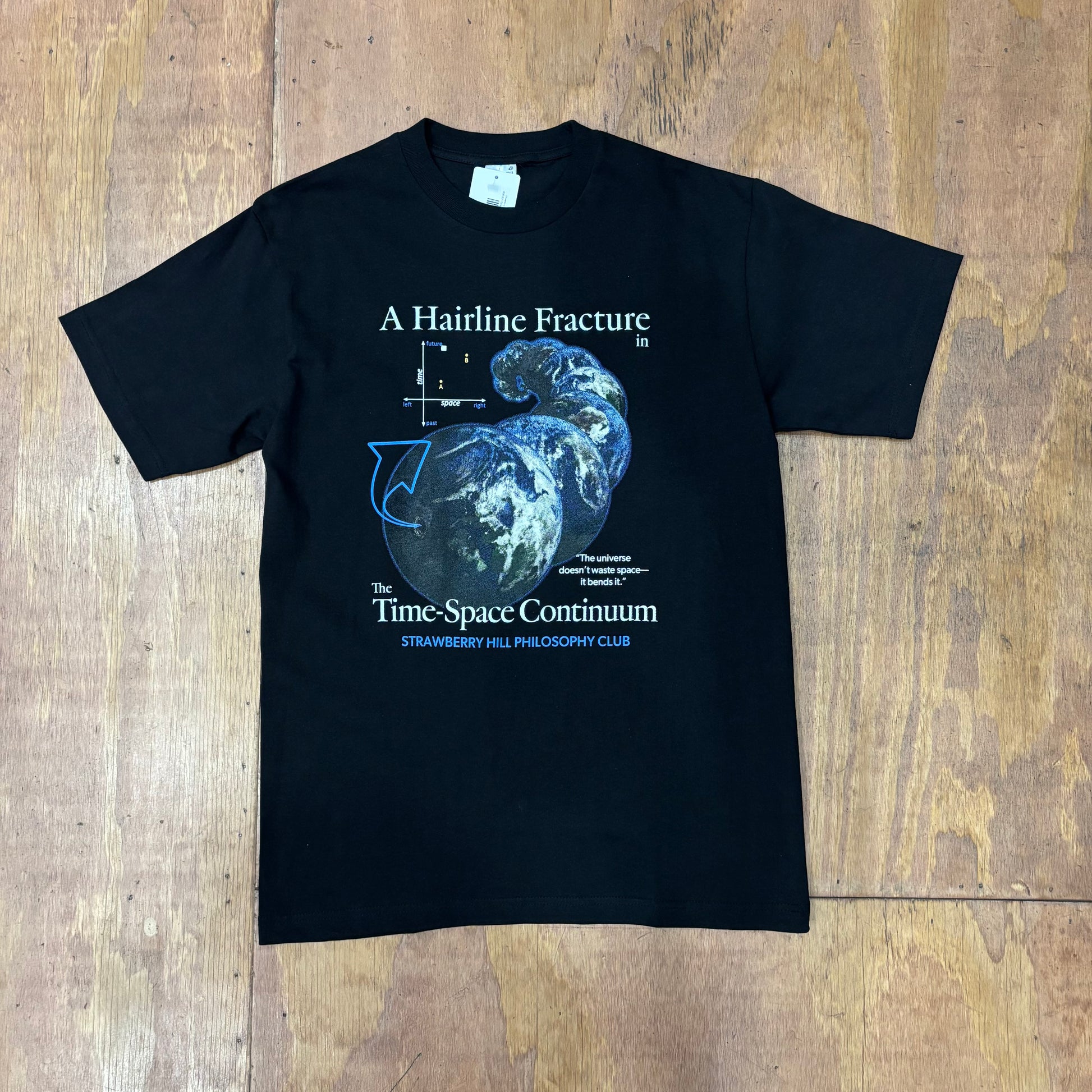 front view of graphic on black -shirt that says 'a hairline fracture in timespace continuum'