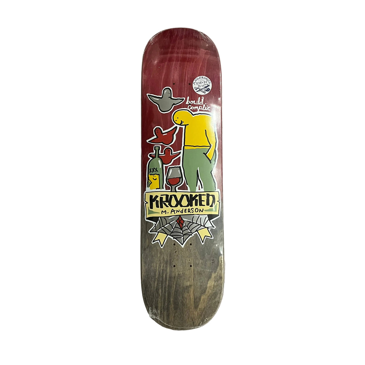 A Krooked skateboard deck with a red and black gradient graphic design, featuring a cartoon character and wine-themed illustrations, resting on a white surface.