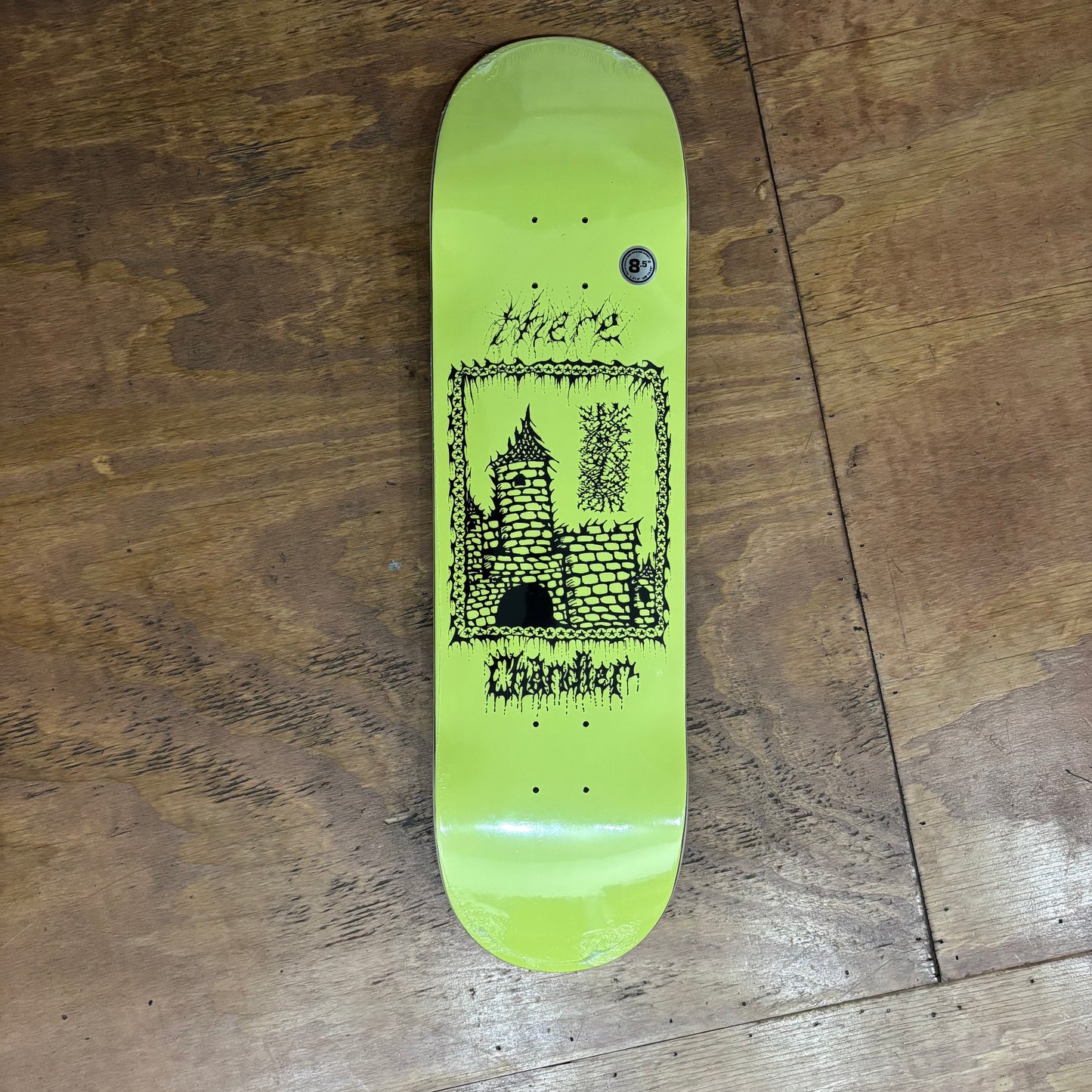 hand drawn graphic of castle on yellow skateboard deck
