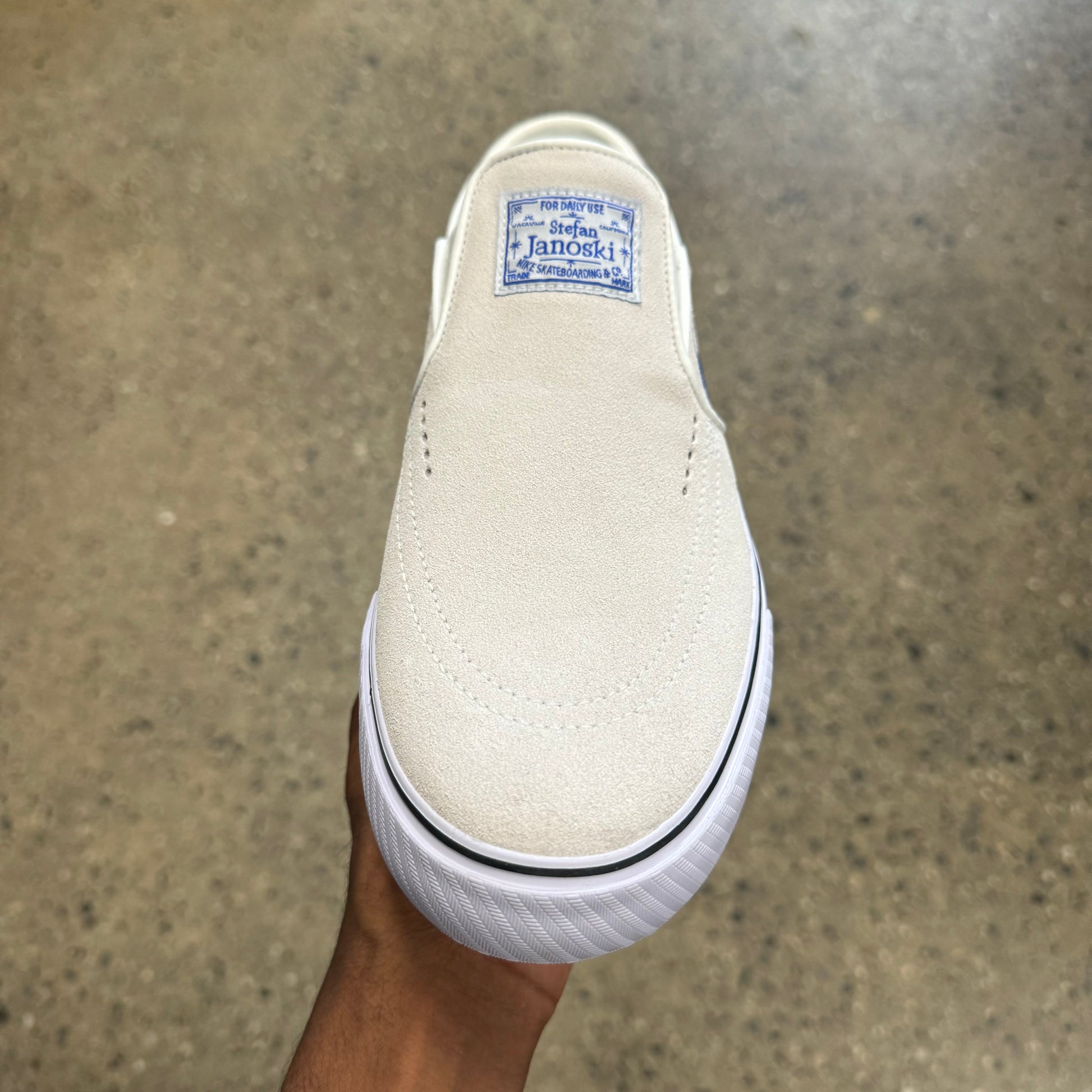 front view. white suede shoe blue logo