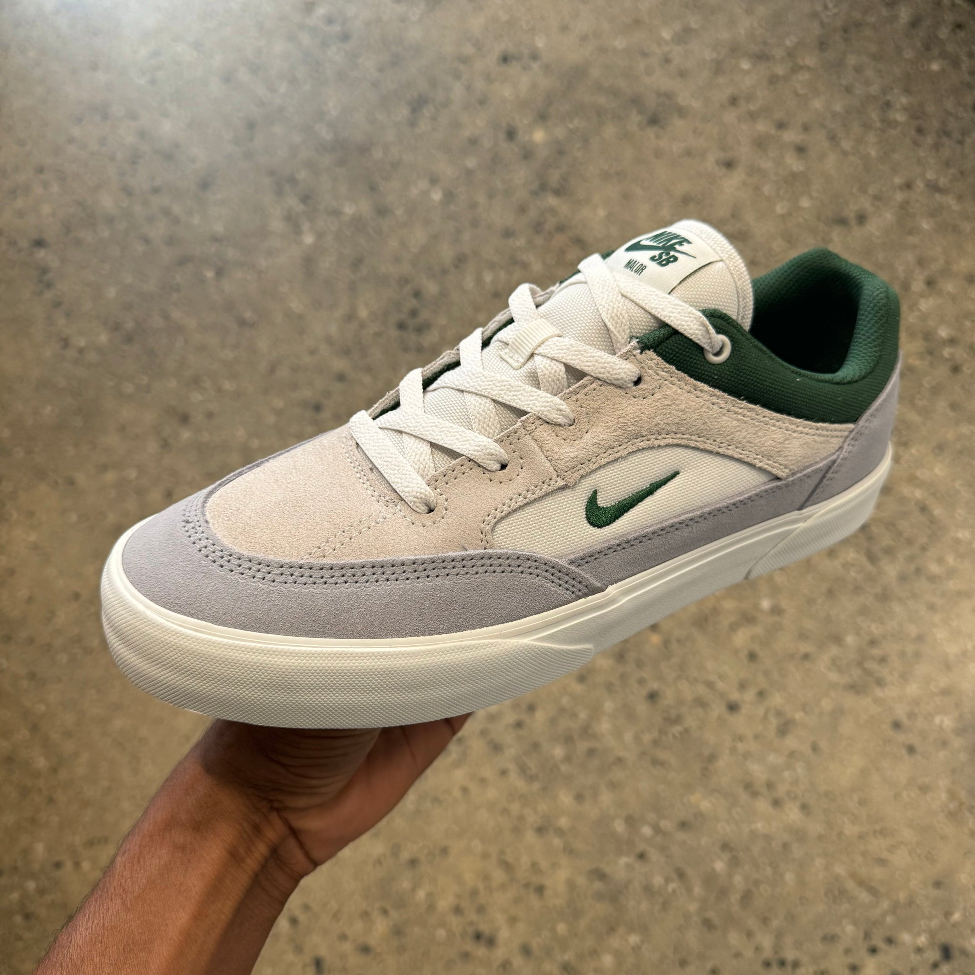 white/grey suede shoe with forest green accents and logos