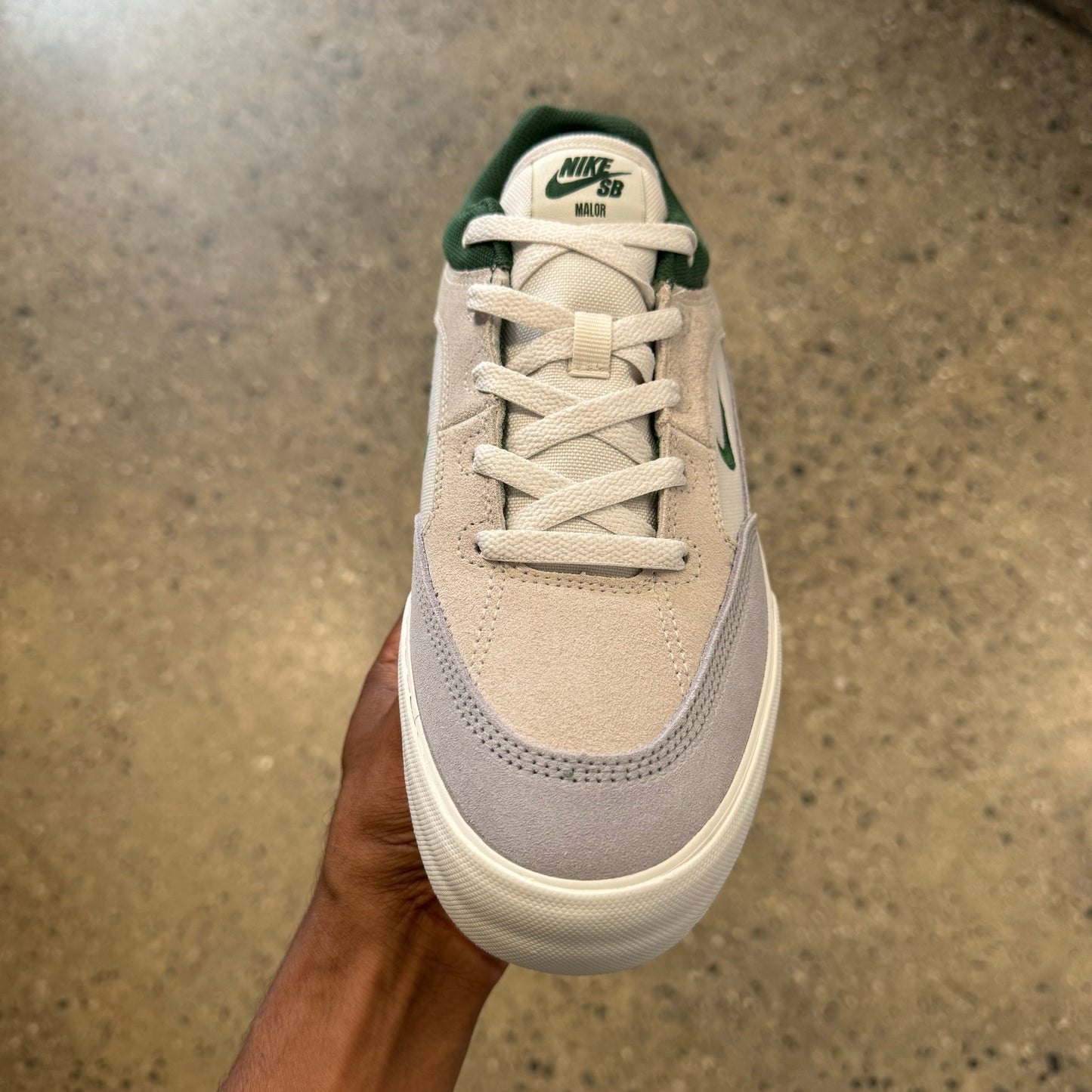 white/grey suede shoe with forest green accents and logos