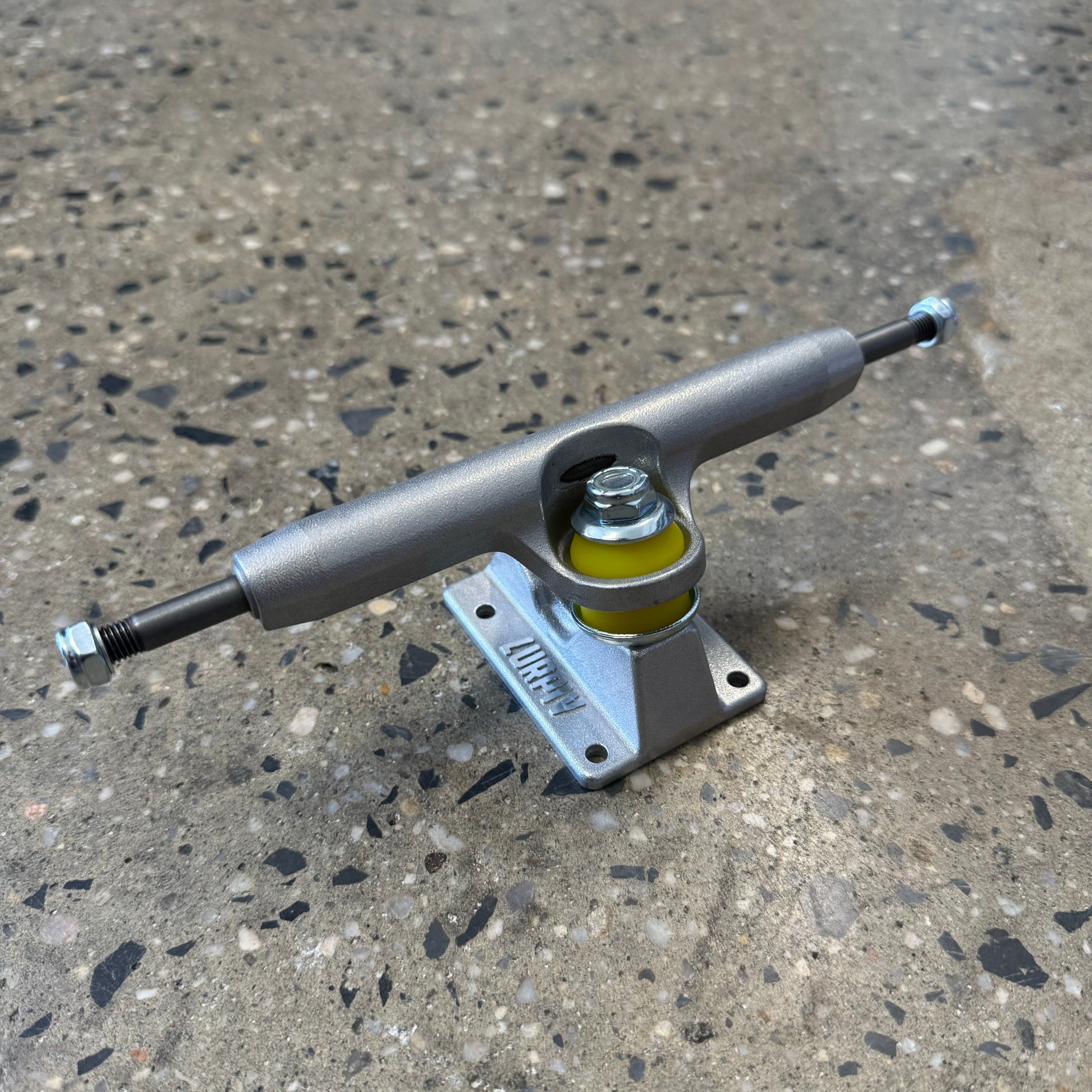 Polished silver skateboard truck. yellow bushing