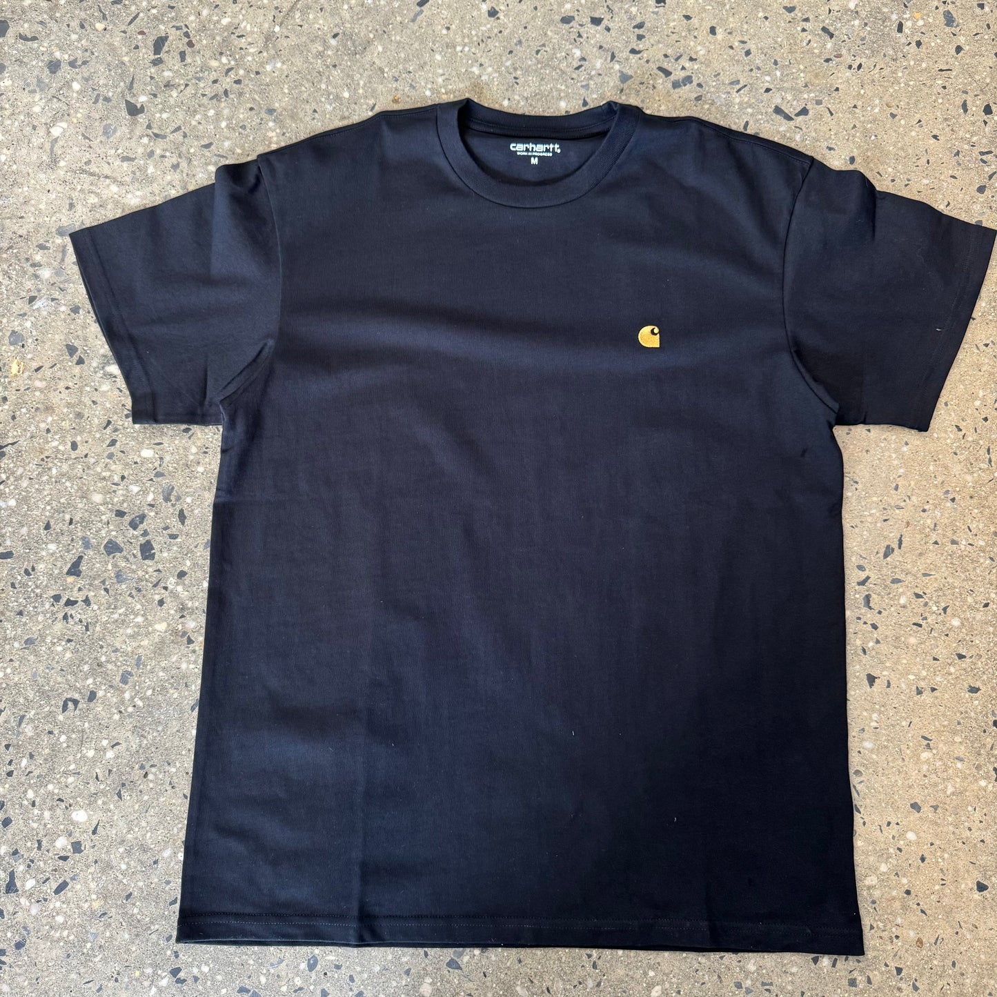 black t shirt with small gold logo