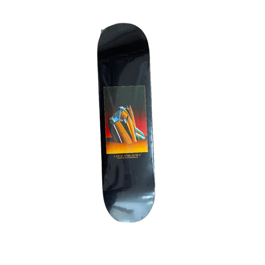 black skateboard deck with car sticking out of a beach