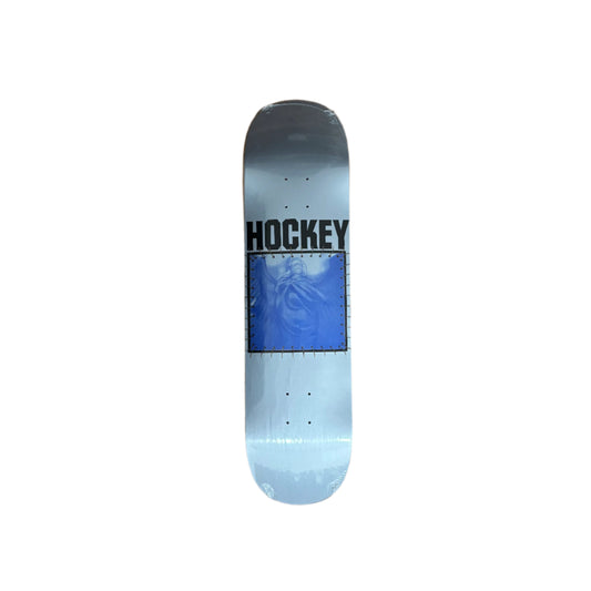 grey and blue skateboard deck with faint image of humans and HOCKEY written above