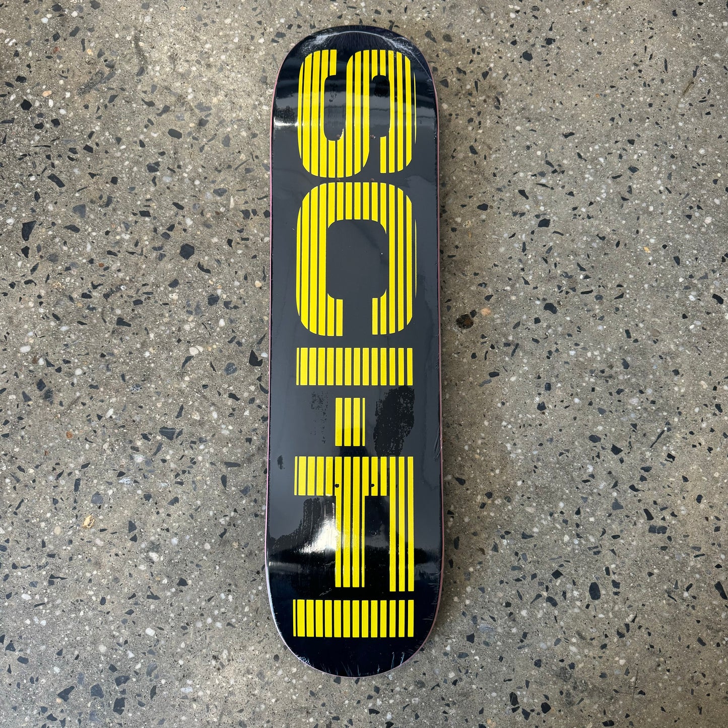 black skateboard deck with big yellow text