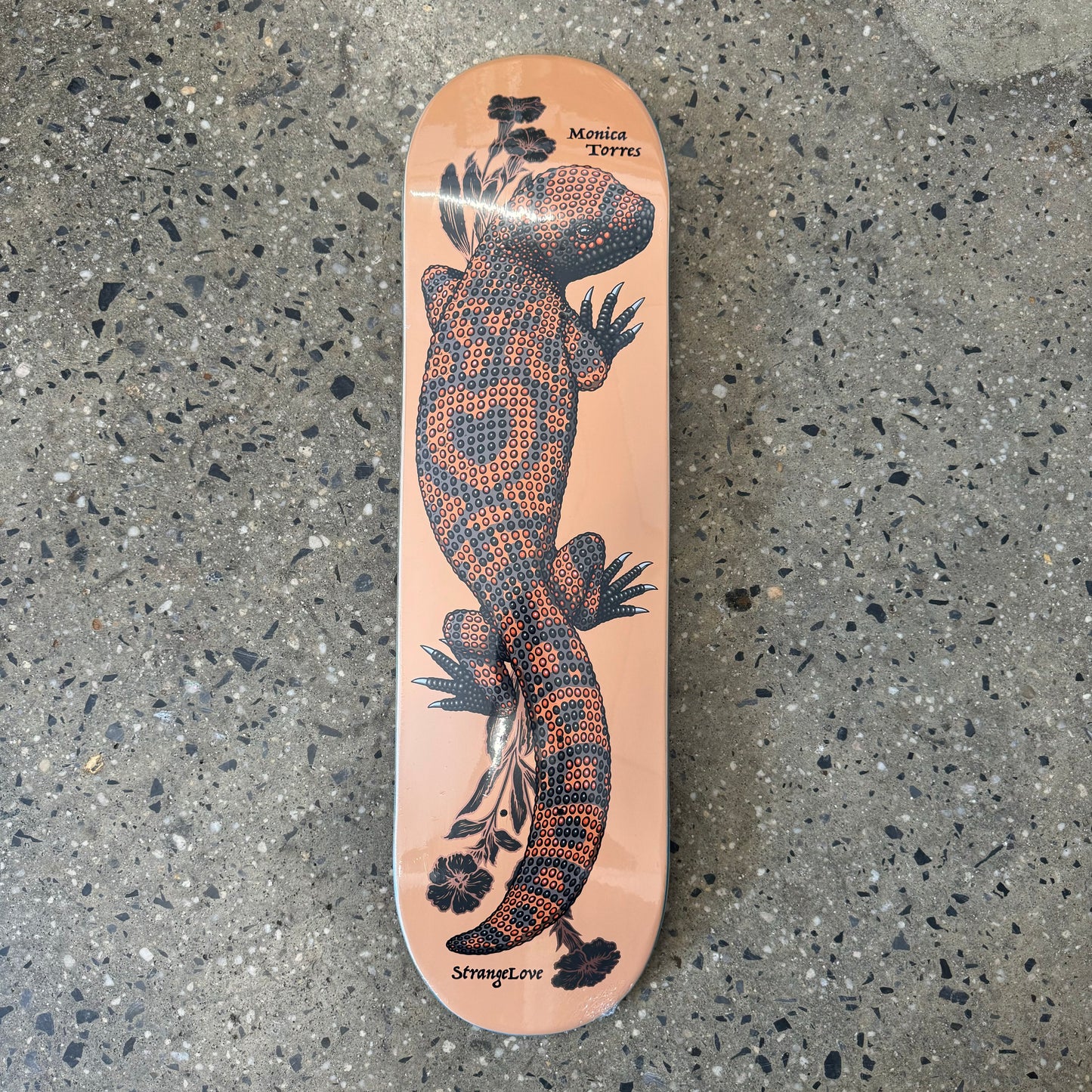 peach colored skateboard deck with a beaded lizard