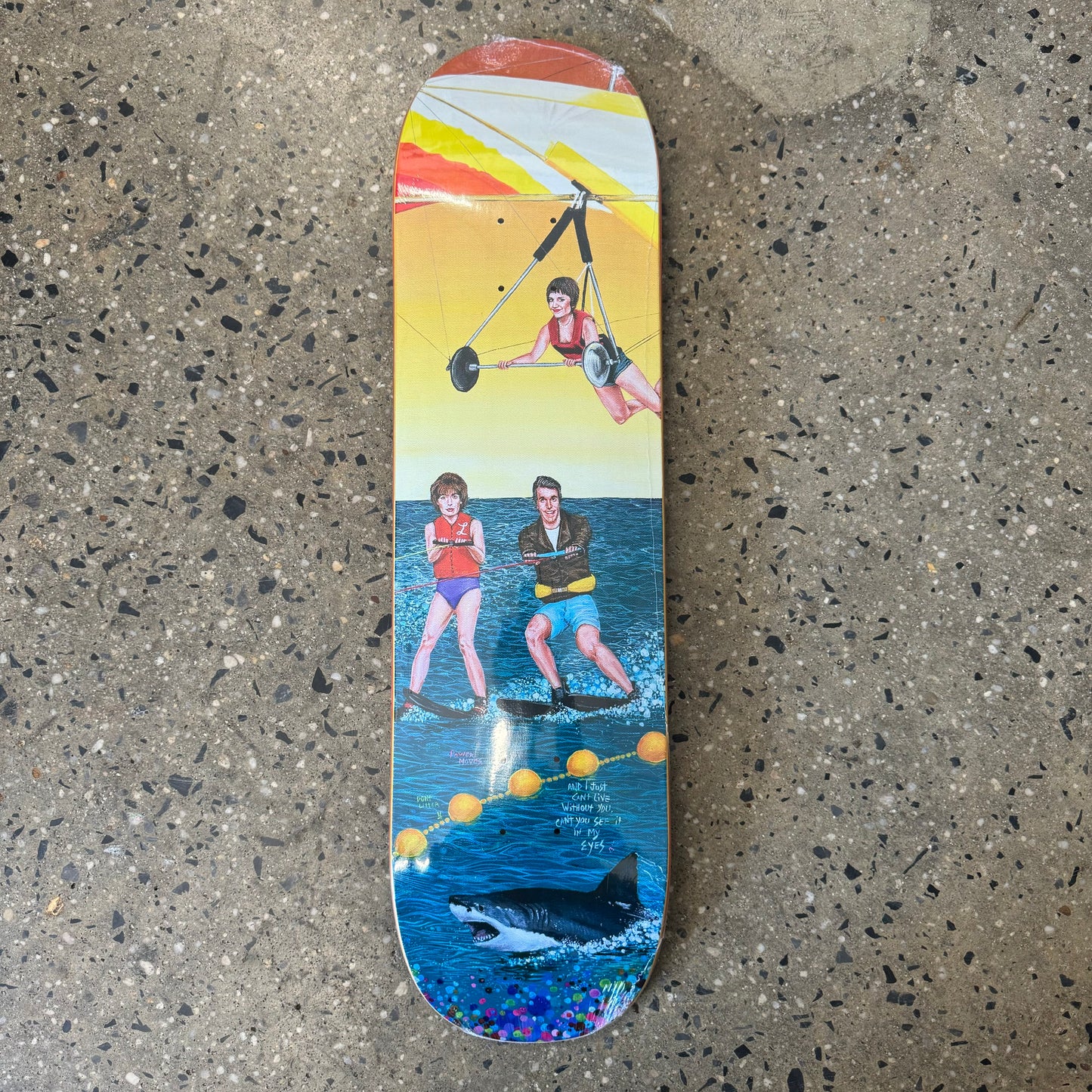 Multicolored Skateboard deck with 2 women and a man water skiing